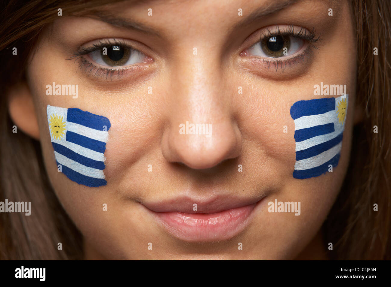 Jeune femme fan de sport avec drapeau uruguayen a peint sur le visage Banque D'Images