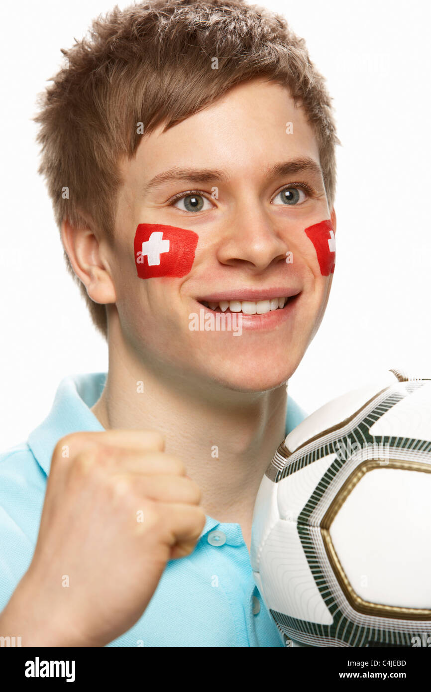 Jeune homme amateur de football avec drapeau suisse peint sur le visage Banque D'Images