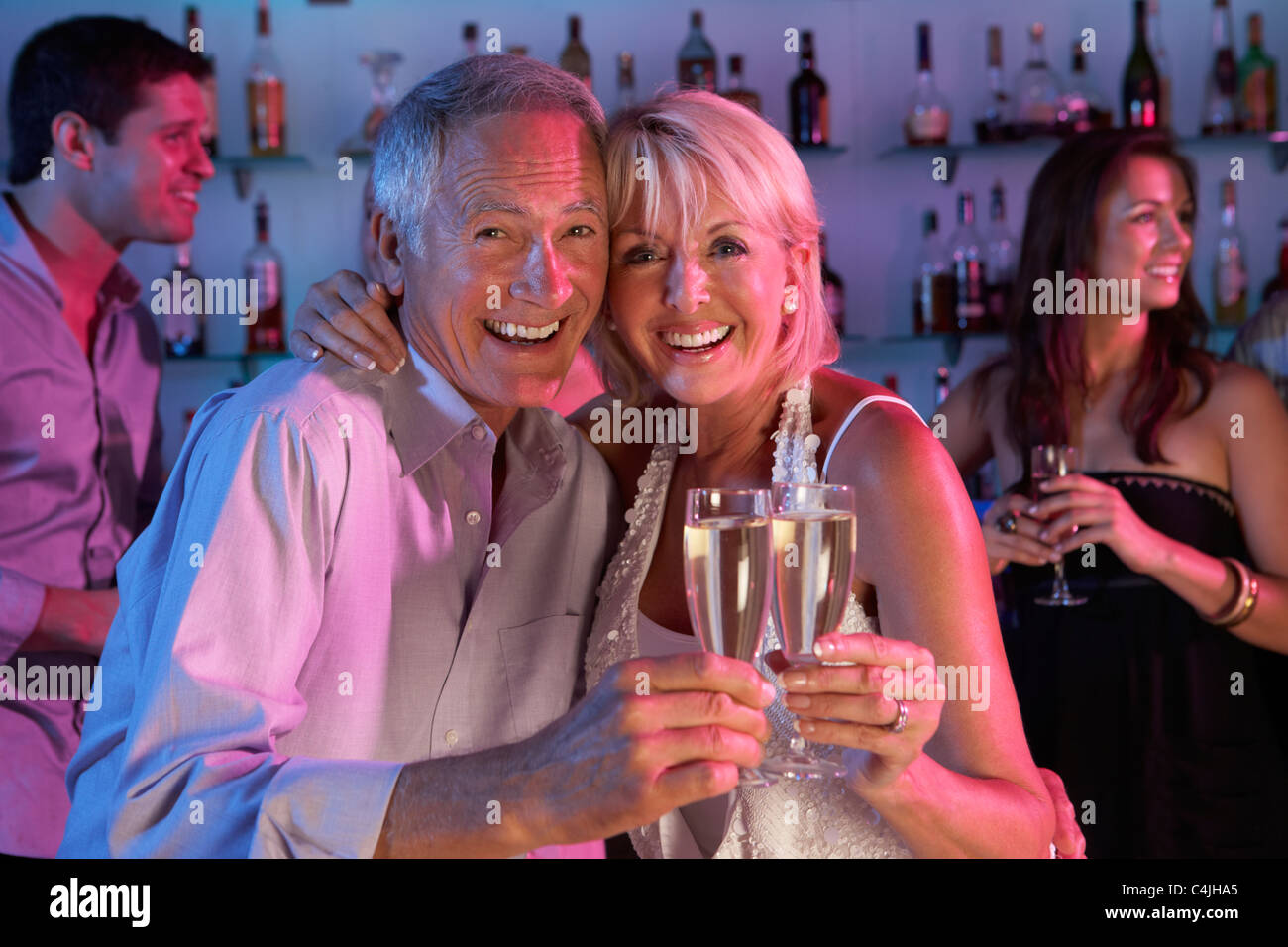 Senior Couple Having Fun In Busy Bar Banque D'Images