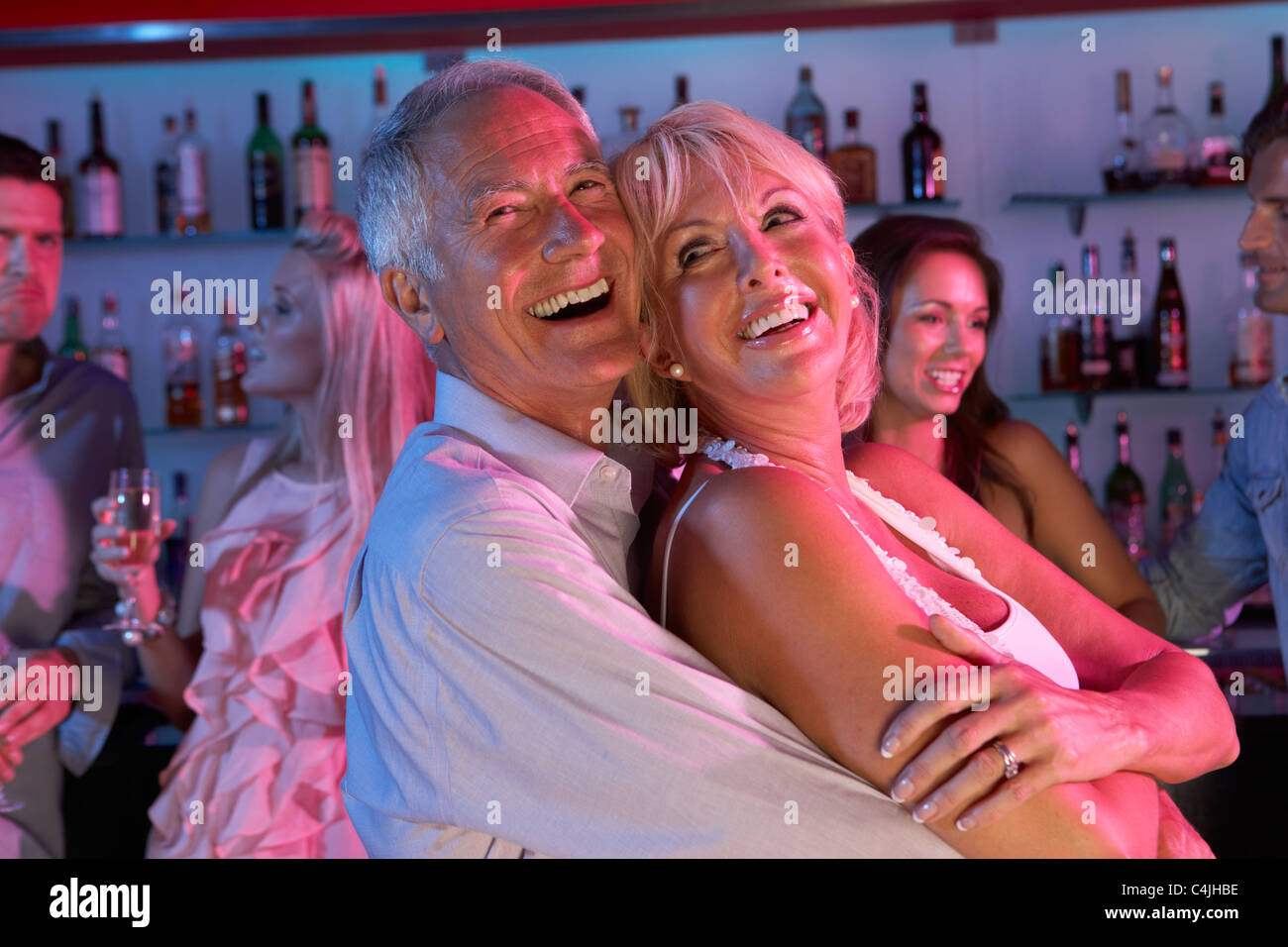 Senior Couple Having Fun In Busy Bar Banque D'Images