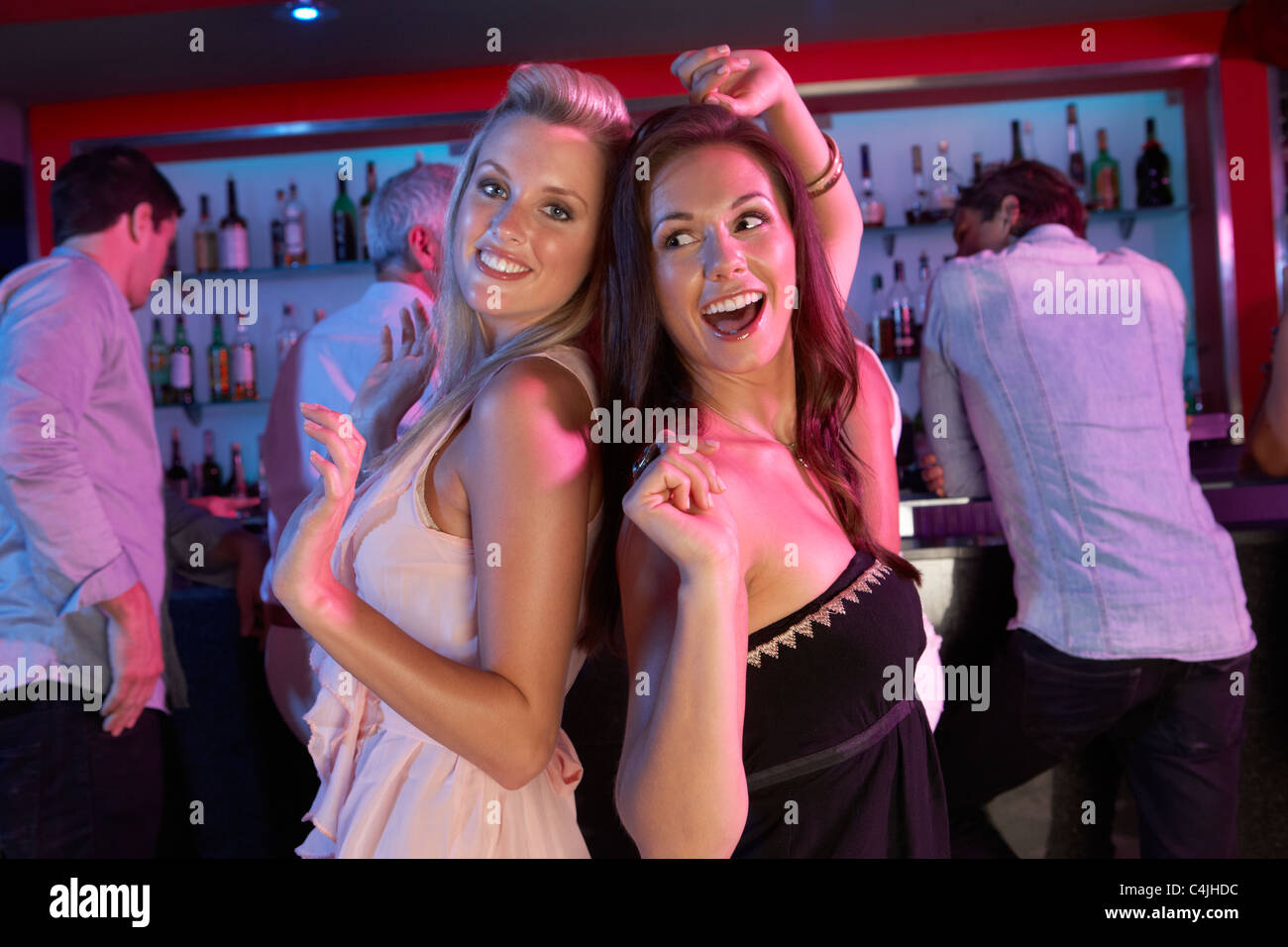 Deux jeunes femmes Having Fun In Busy Bar Banque D'Images