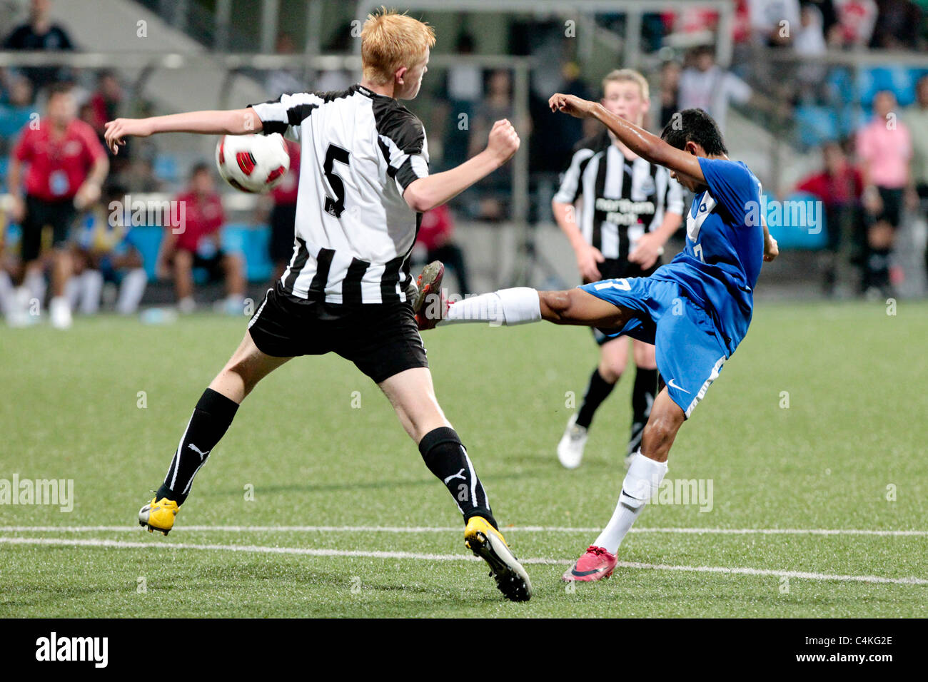 Zulfadhmi Suzliman de Singapour U15(bleu) de volée un tir de juste à l'intérieur de la zone de pénalisation au cours de la 23e Coupe de la ville de Lion de Canon. Banque D'Images