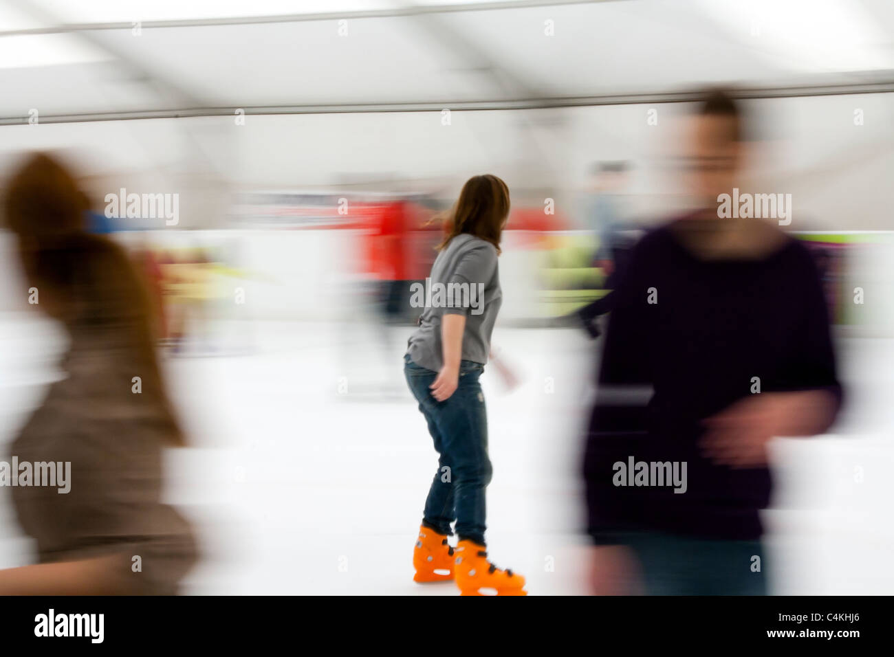 Femme de patinage avec motion blurred crowd Banque D'Images