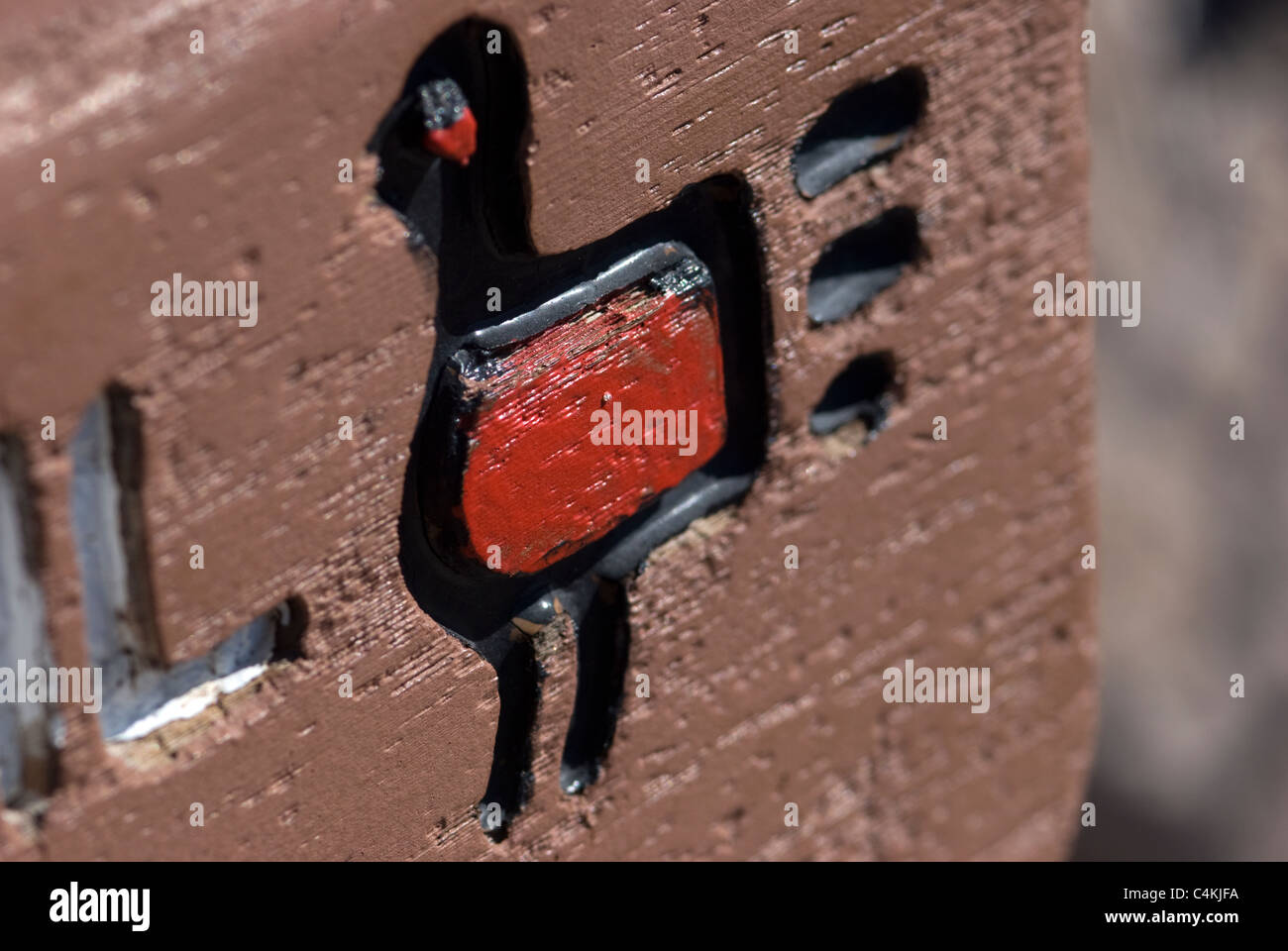 Un signe en bois avec un pétroglyphe Turquie Merriam stylisé, le symbole officiel de Bandelier National Monument : Falls Trail. Banque D'Images
