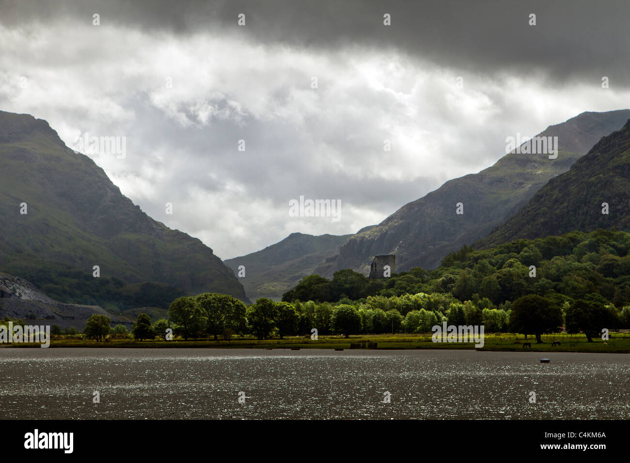 Moody nuages sur Llyn Padarn (lac) à Llanberis, Snowdonia, le nord du Pays de Galles, avec en arrière-plan le château de Dolbadarn Banque D'Images