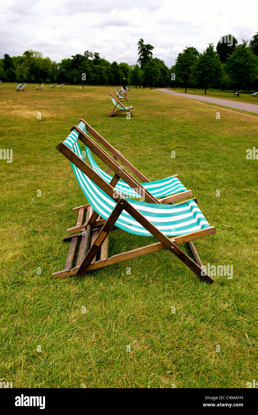 Chaises longues dans les jardins de Kensington près de bassin rond, Londres ; Liegestühle im Park Kensington Gardens, Londres Banque D'Images