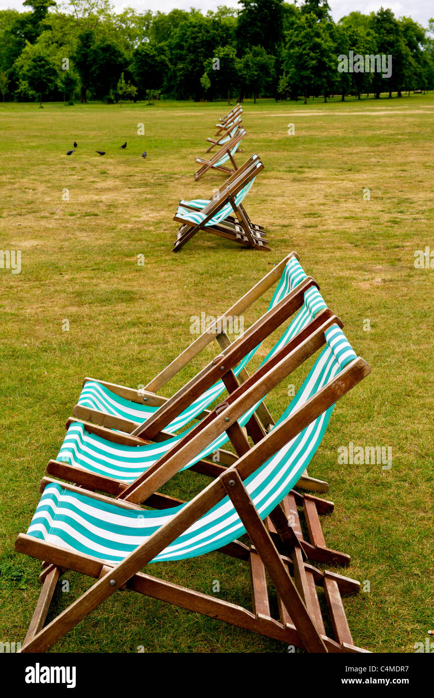 Chaises longues dans les jardins de Kensington près de bassin rond, Londres ; Liegestühle im Park Kensington Gardens, Londres Banque D'Images