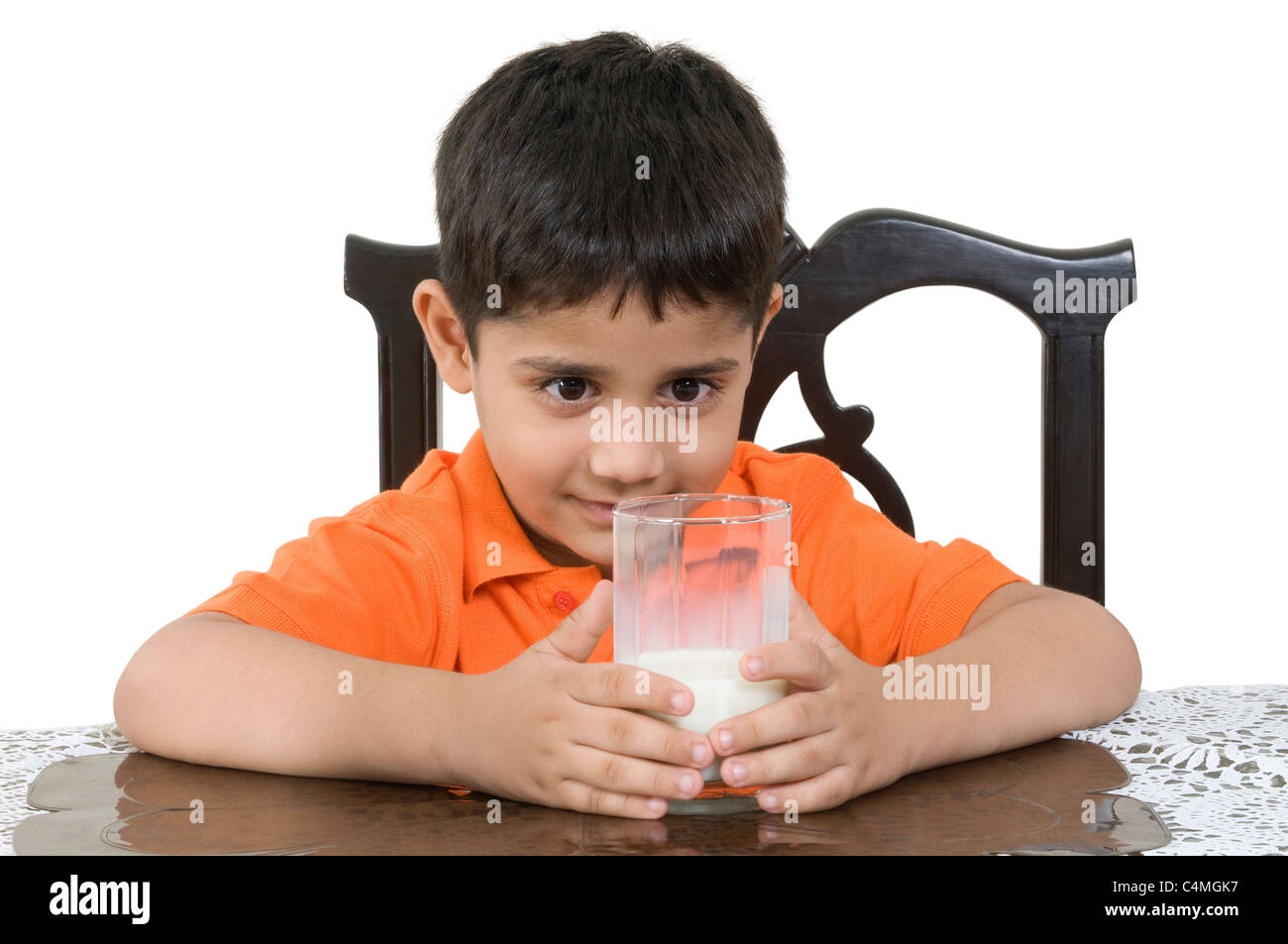 Un petit garçon Indien tenant un verre de lait. Banque D'Images