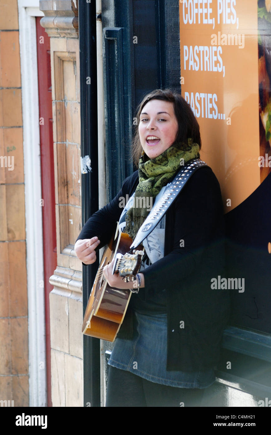 Jeune chanteuse de la rue avec une guitare, Aberystwyth, Pays de Galles. Banque D'Images