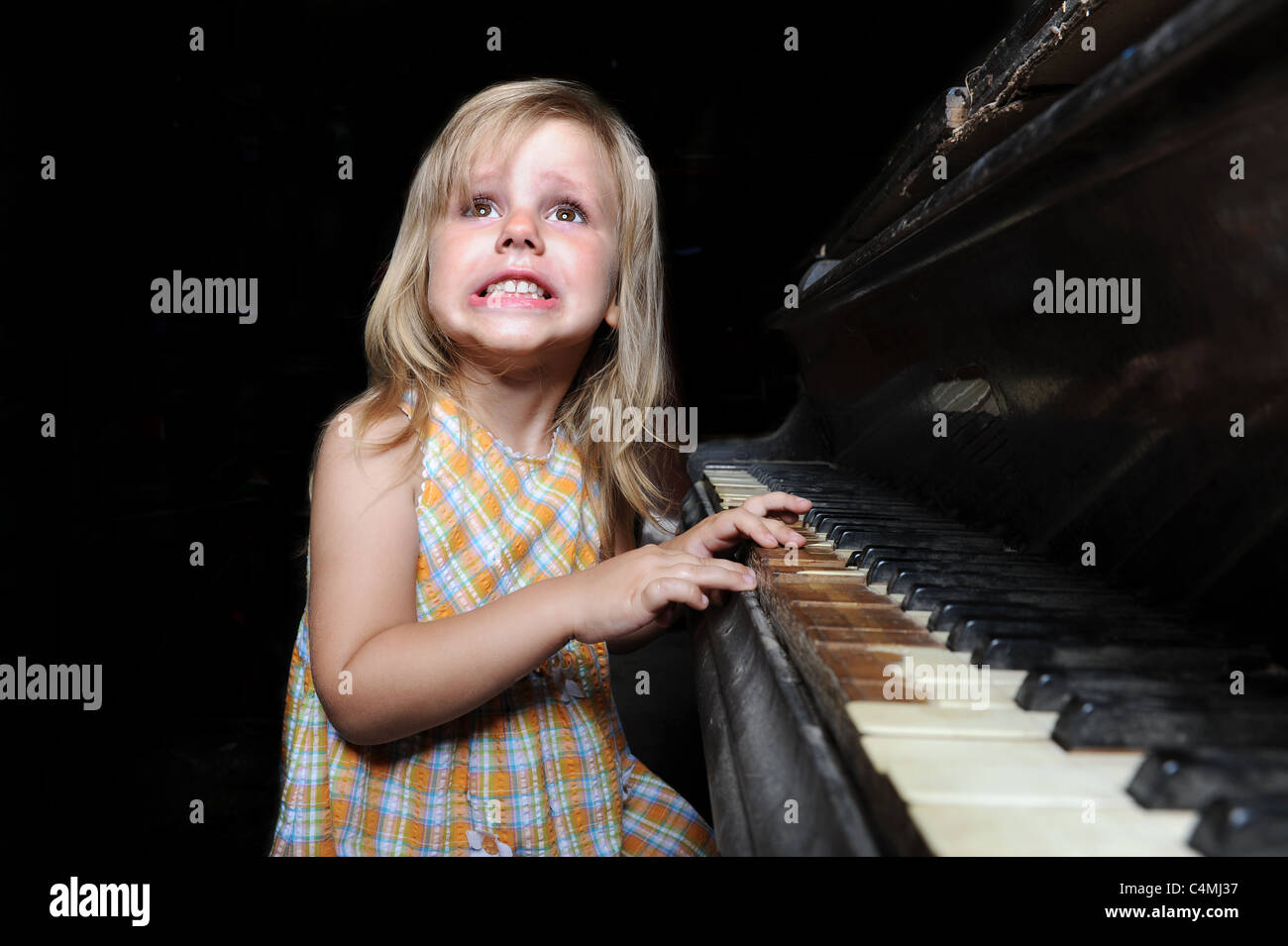 Fille jouant sur un piano. Banque D'Images