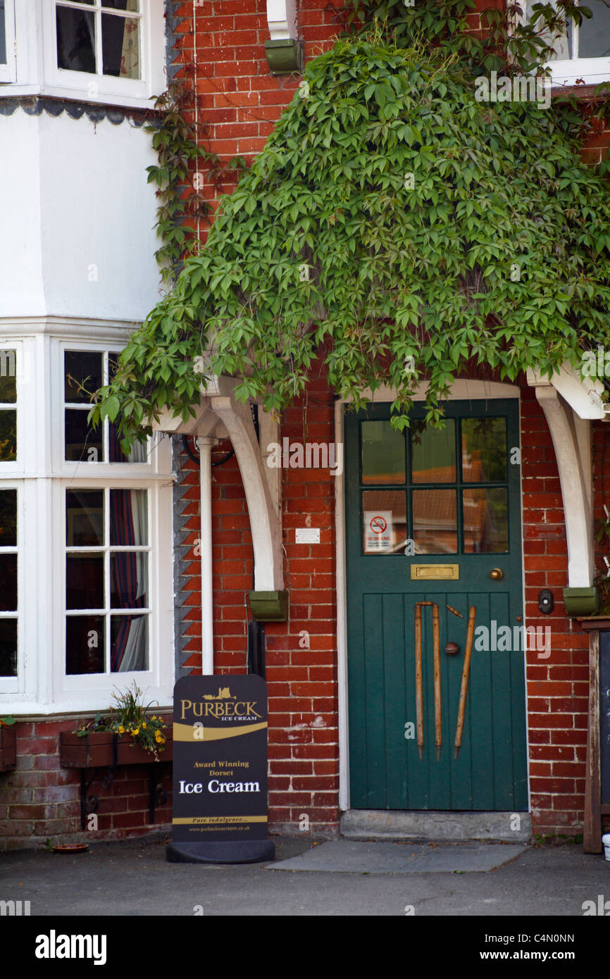 Les souches et de cricket ball sur la porte d'entrée à l'Cricketers pub dans Irwerne Courtney, Dorset au printemps Banque D'Images
