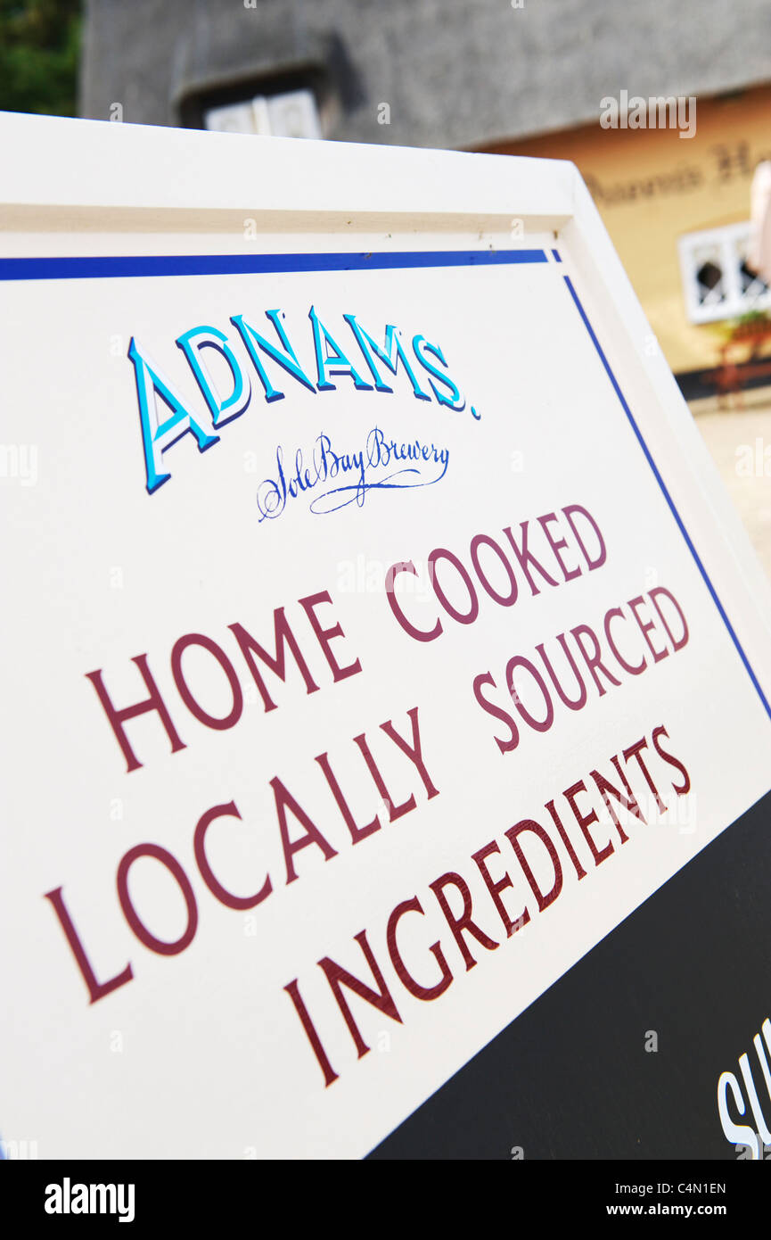 Enseigne à l'extérieur The Queens Head, public house près de Maidstone, dans le Suffolk. Pub historique typique avec un toit de chaume Banque D'Images