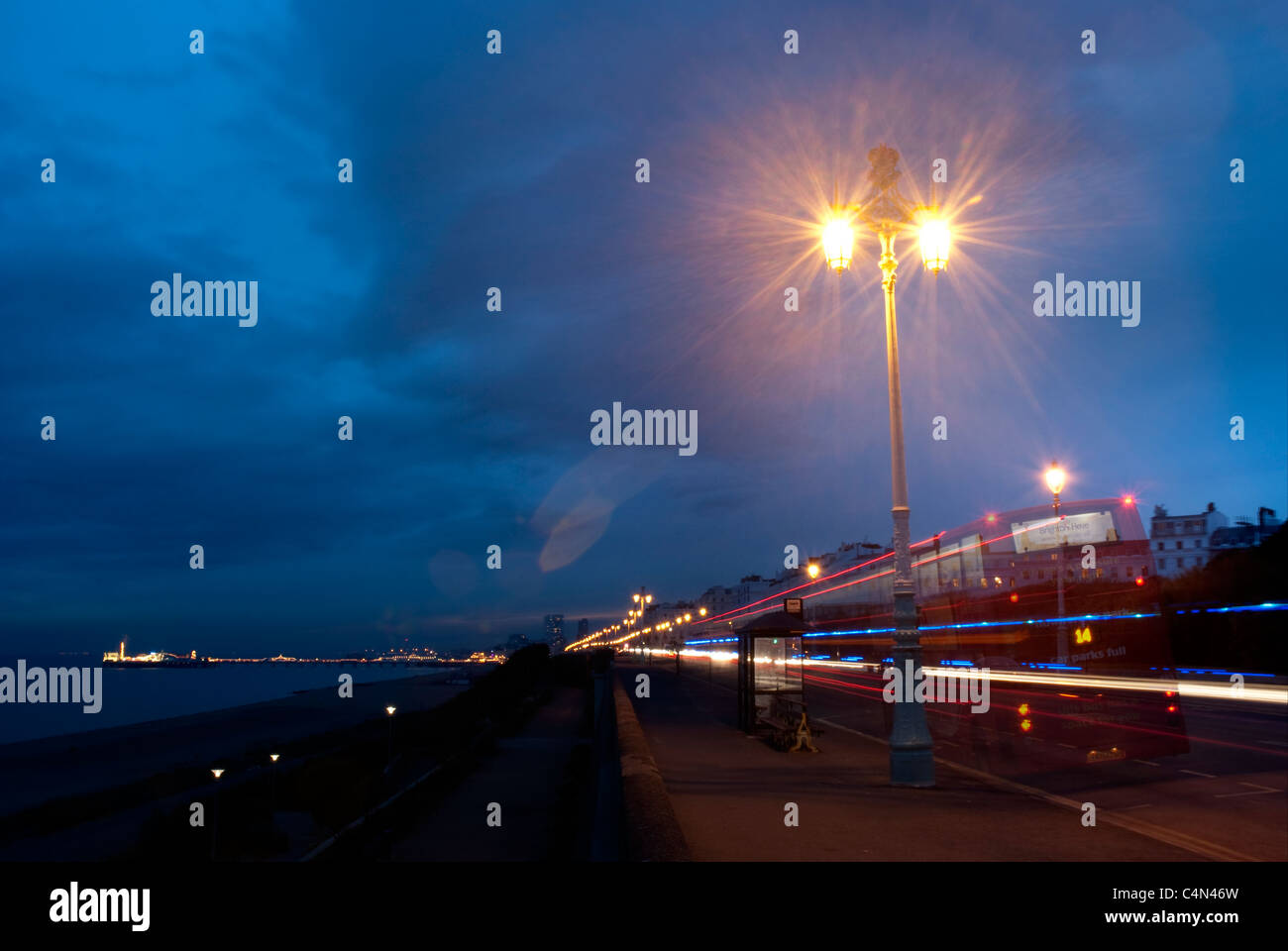 Front de mer de Brighton dans la nuit avec les feux de voitures et bus striée Banque D'Images