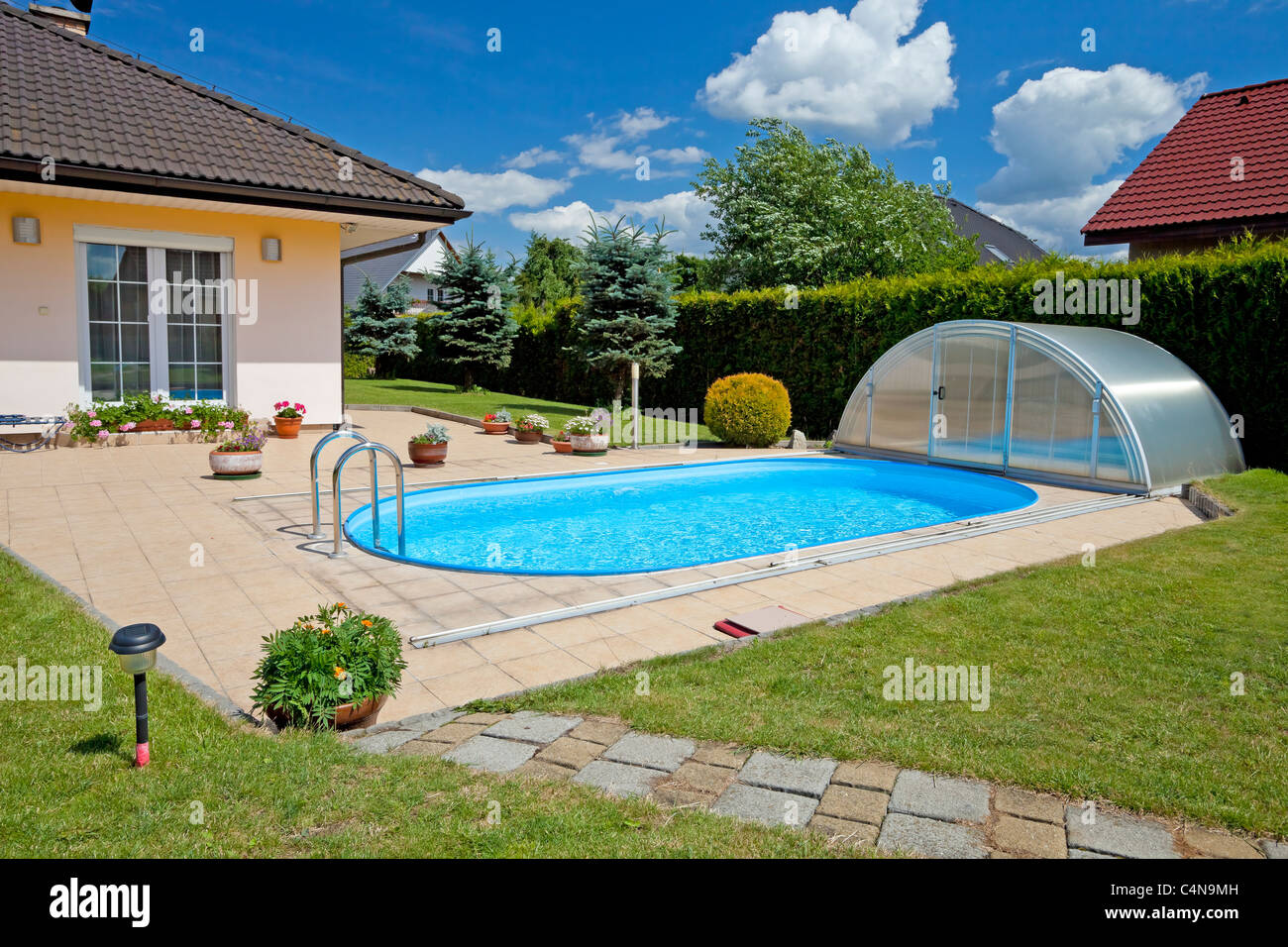 La piscine avec le jardin et la maison Banque D'Images