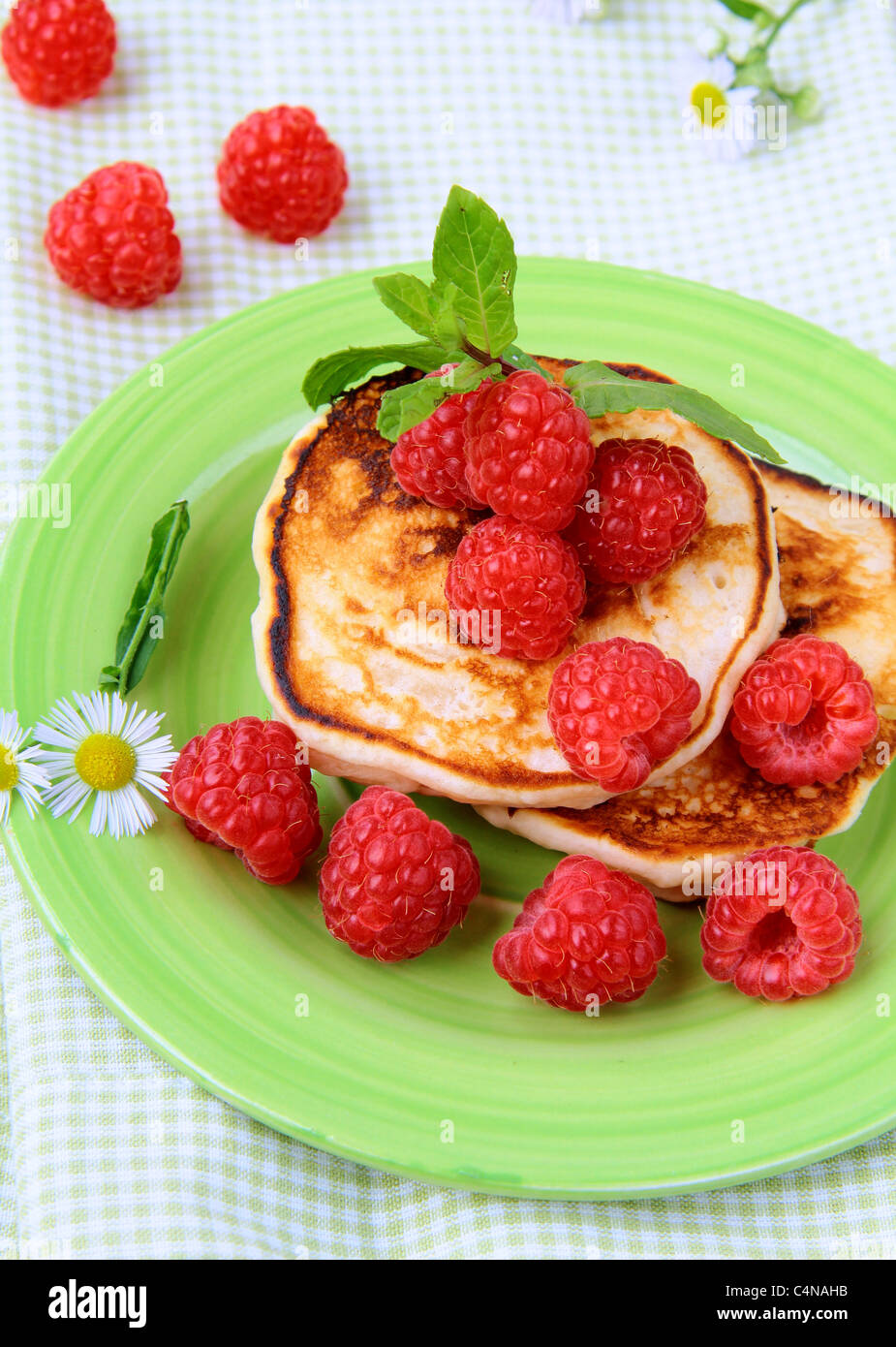 Mini crêpes avec les framboises mûres et de menthe pour le petit déjeuner Banque D'Images