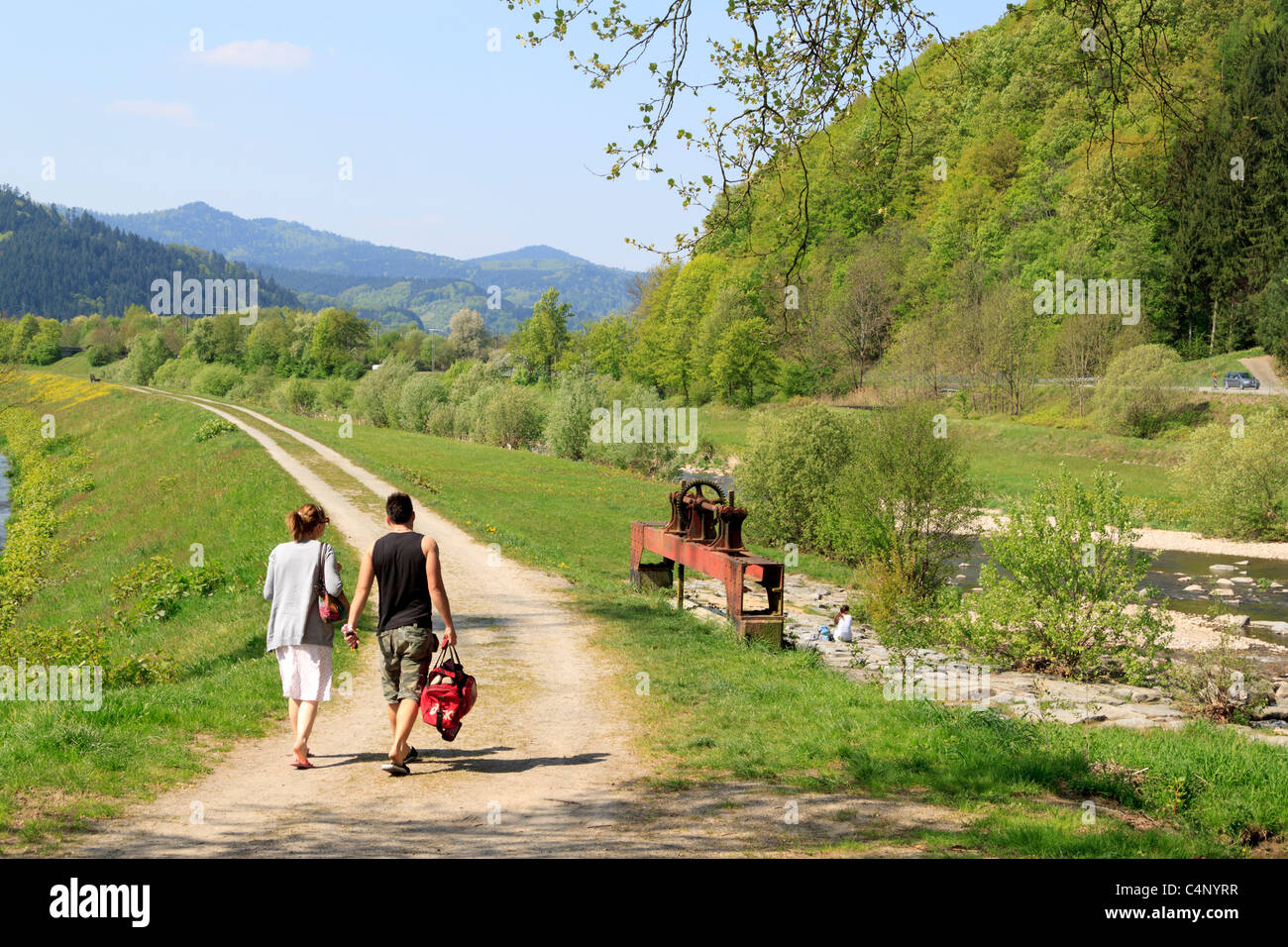 Un couple en train de marcher sur les rives de la rivière Kinzig dans le district Ortenaukreis de la Forêt-Noire, Schwarzwald, Allemagne Banque D'Images