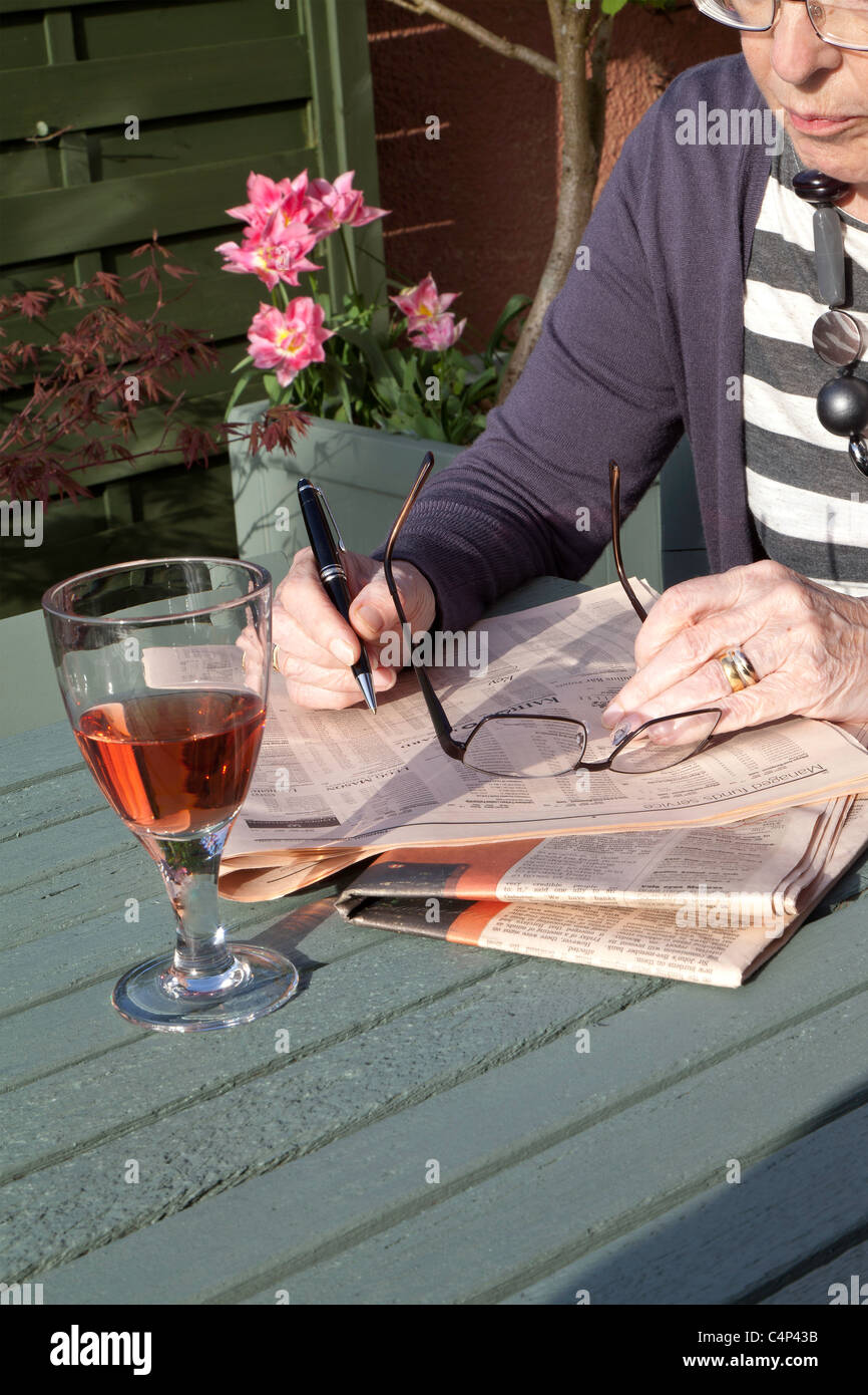 Femme PLUS ÂGÉE LISANT FINANCIAL TIMES Banque D'Images