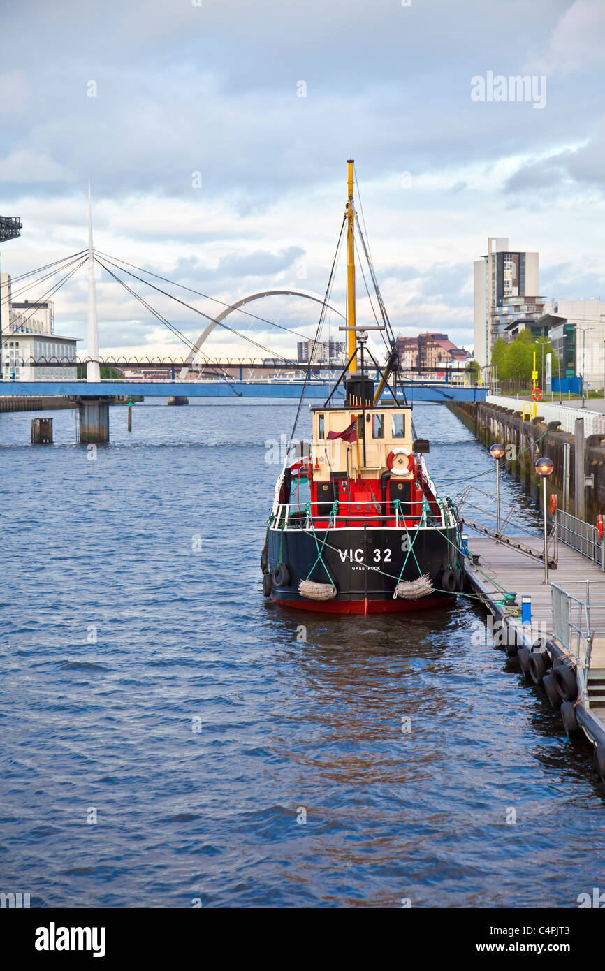 Le plus léger à vapeur 32 VIC accostera au quai du Pacifique sur la rivière Clyde avec des cloches et le pont d'Arc de Glasgow à l'arrière-plan. Banque D'Images