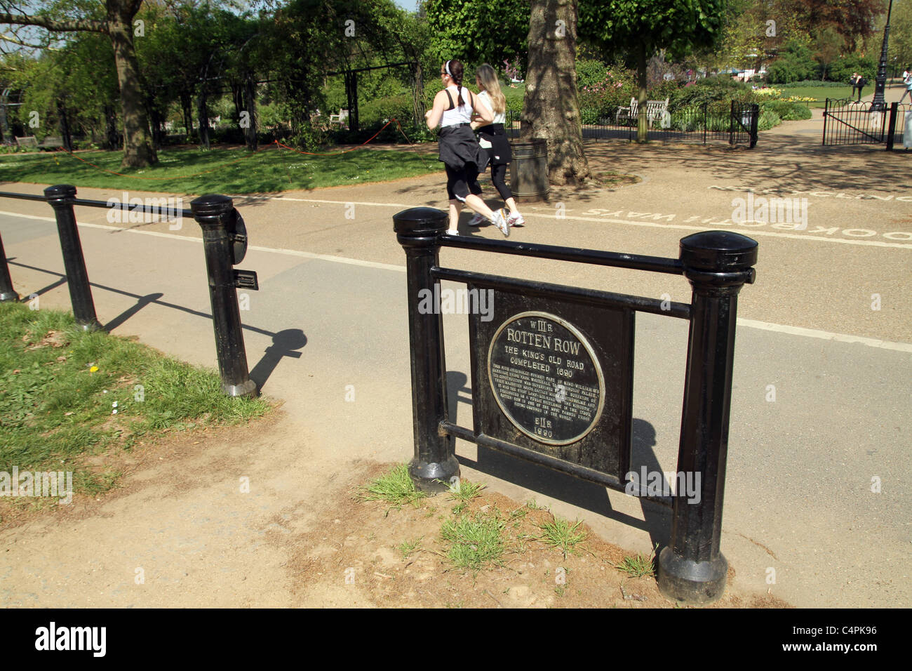 Les femmes passent devant un signe marquant la ligne pourrie, le XVII siècle le long de la vieille ROUTE DU ROI, Hyde Park, London,UK Banque D'Images