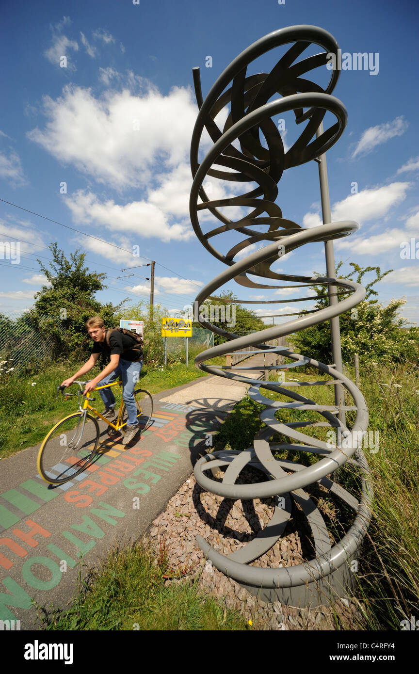 Cycliste passant sur la sculpture ADN cycle path Cambridge Banque D'Images