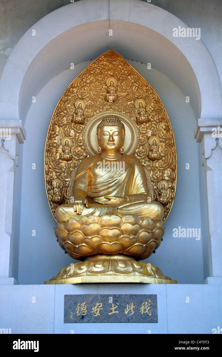 Golden Buddha statue (lumières) dans le nord de la place de la Pagode de la paix bouddhiste japonaise, Battersea Park, London, UK. Banque D'Images