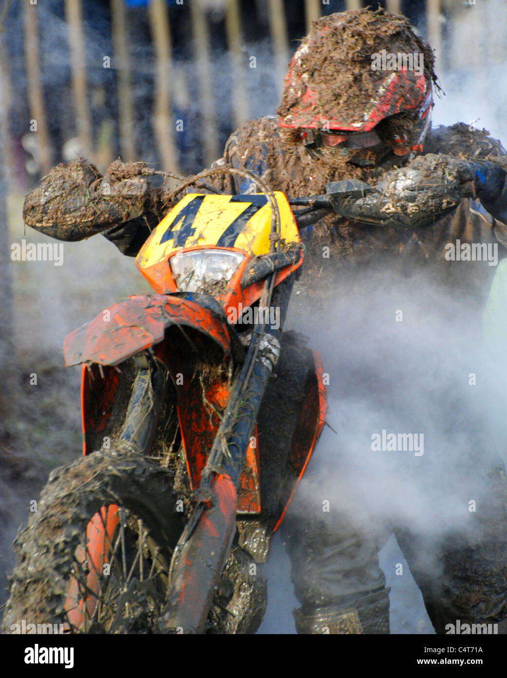 Motor bike rider vélo poussant hors de la boue pendant la course enduro Banque D'Images
