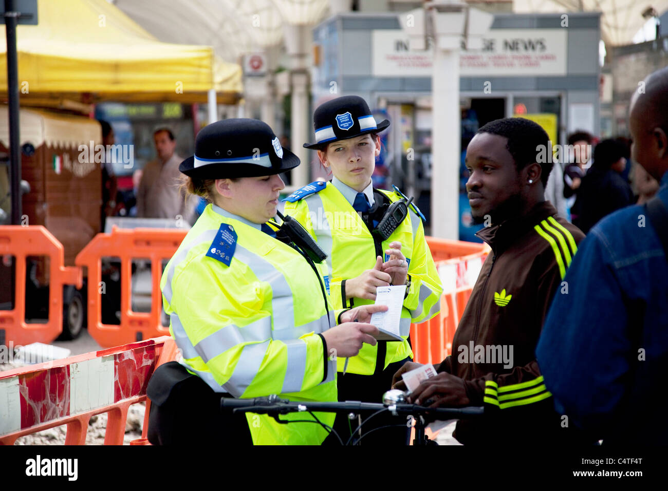 Un jeune homme noir est mis en garde par des officiers de police à Stratford dans l'Est de Londres, Royaume-Uni. Banque D'Images