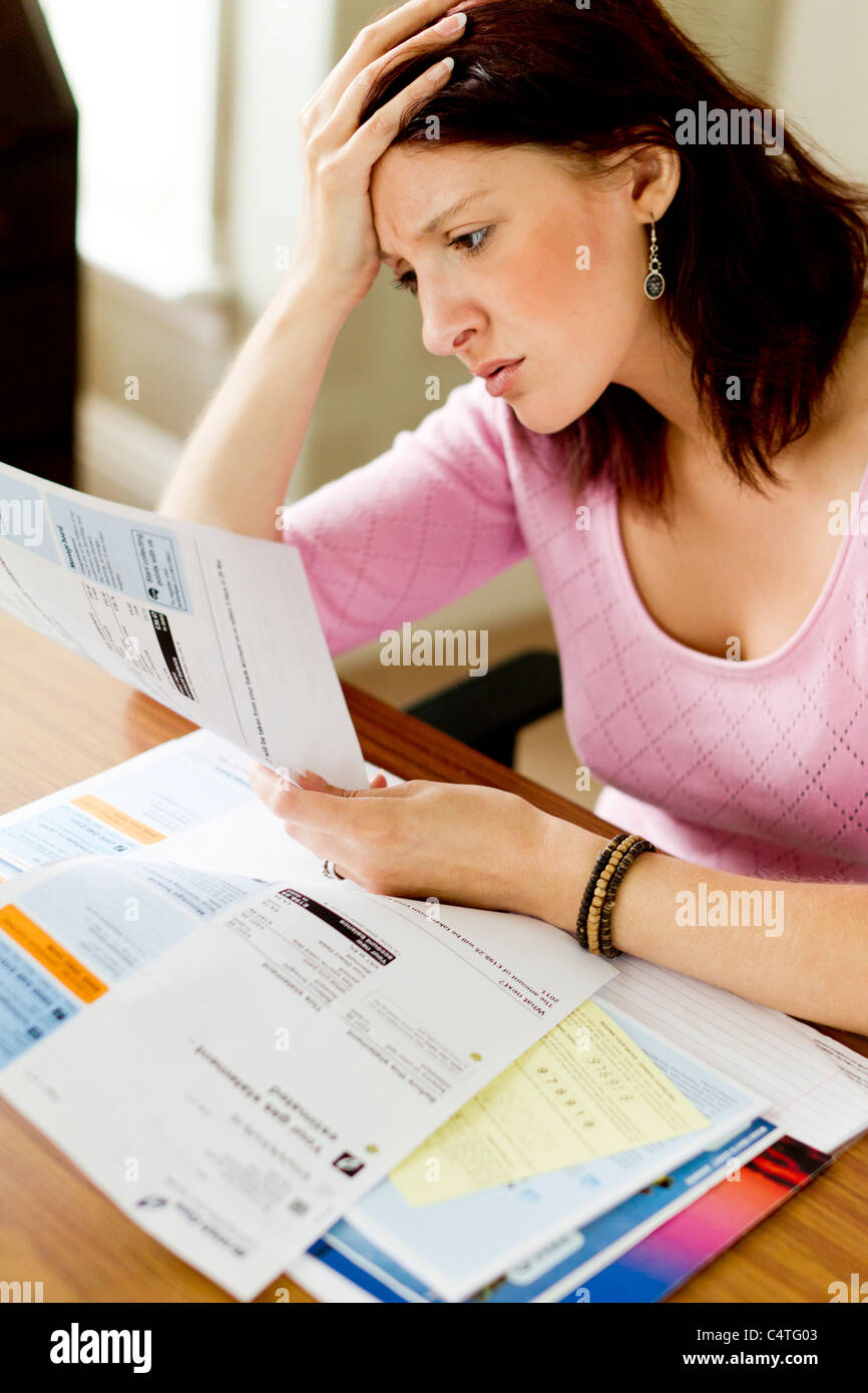 Femme regardant les factures de services Banque D'Images