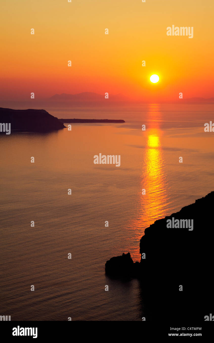 La magnifique île grecque de Santorin coucher de soleil depuis Oia au nord de lueur orange typique de Thira, réfléchissant sur la mer Banque D'Images