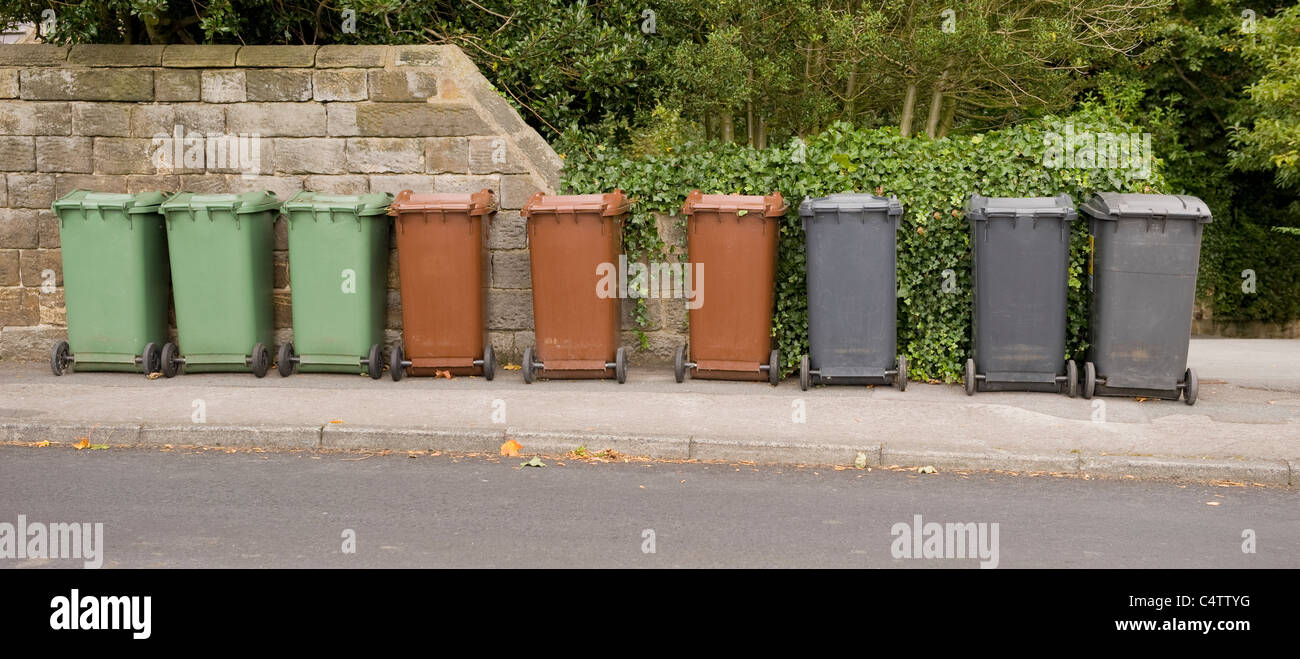 Poubelles à roulettes (gris brun vert) pour déchets domestiques, recyclage et déchets de jardin alignées sur la chaussée pour la collecte - Leeds, Yorkshire, Angleterre, Royaume-Uni. Banque D'Images