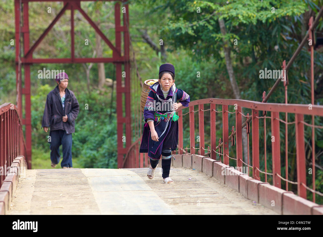 Black H'Mong de minorités ethniques femme marche à travers bridge dans SAPA, Vietnam Banque D'Images