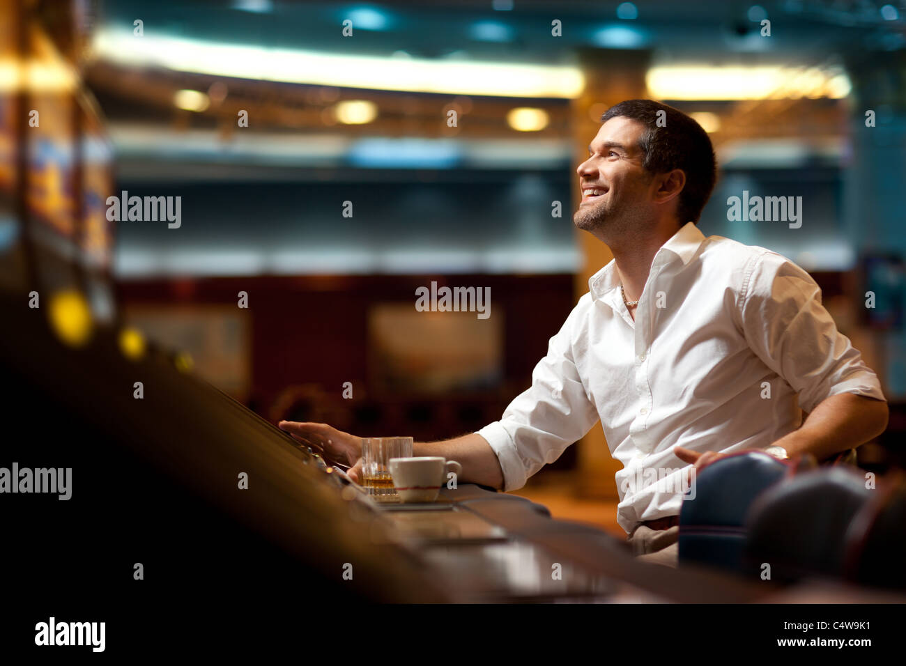 Smiling handsome man l'espoir de gagner à la machine à sous Banque D'Images