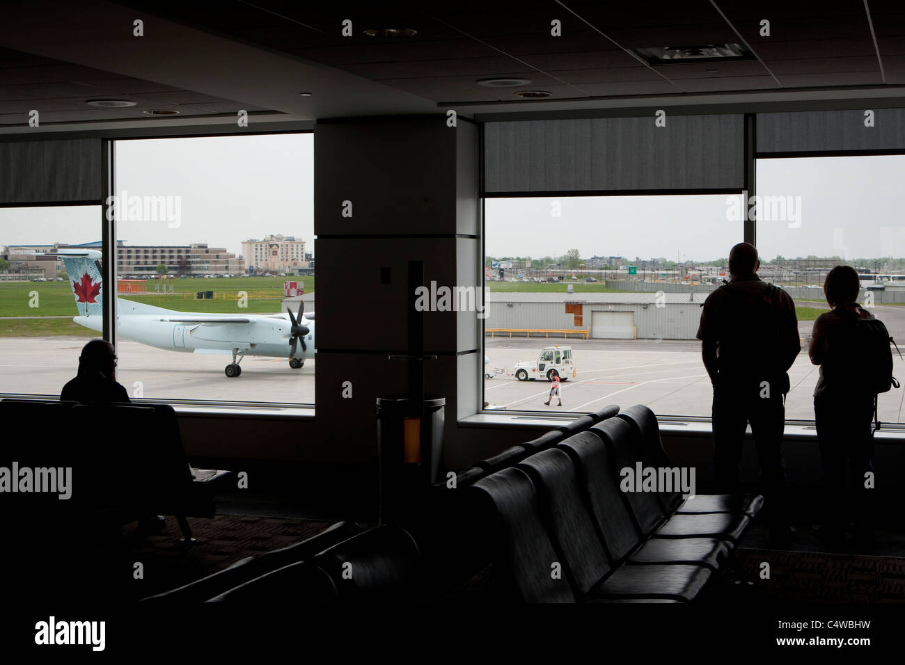 L'équipage de l'aéroport passagers regarder le fonctionnement sur un aéronef DHC-8-402 Air Canada à l'aéroport Pierre-Elliott-Trudeau de Montréal Banque D'Images