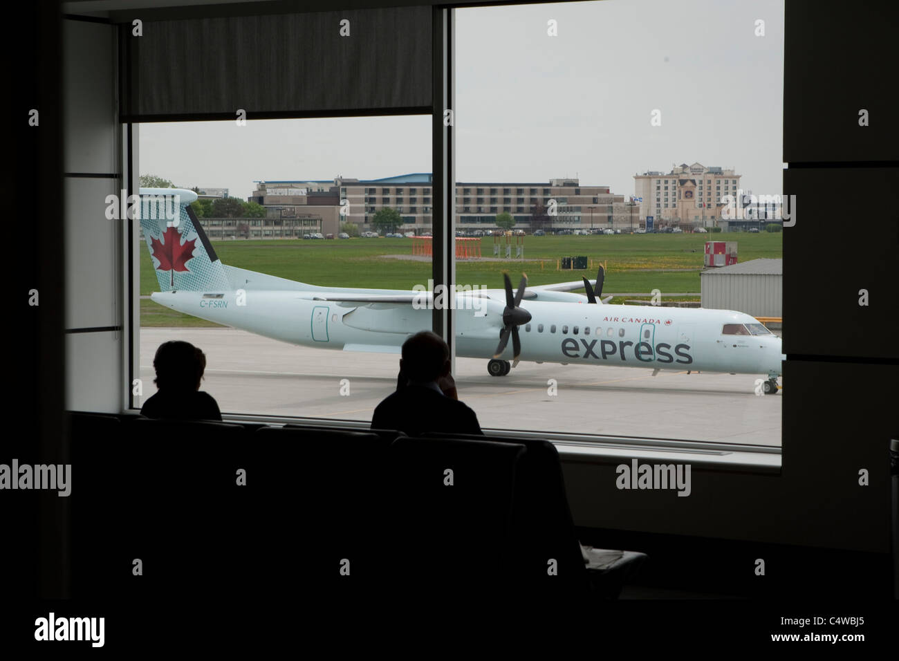 L'équipage de l'aéroport passagers regarder le fonctionnement sur un aéronef DHC-8-402 Air Canada à l'aéroport Pierre-Elliott-Trudeau de Montréal Banque D'Images