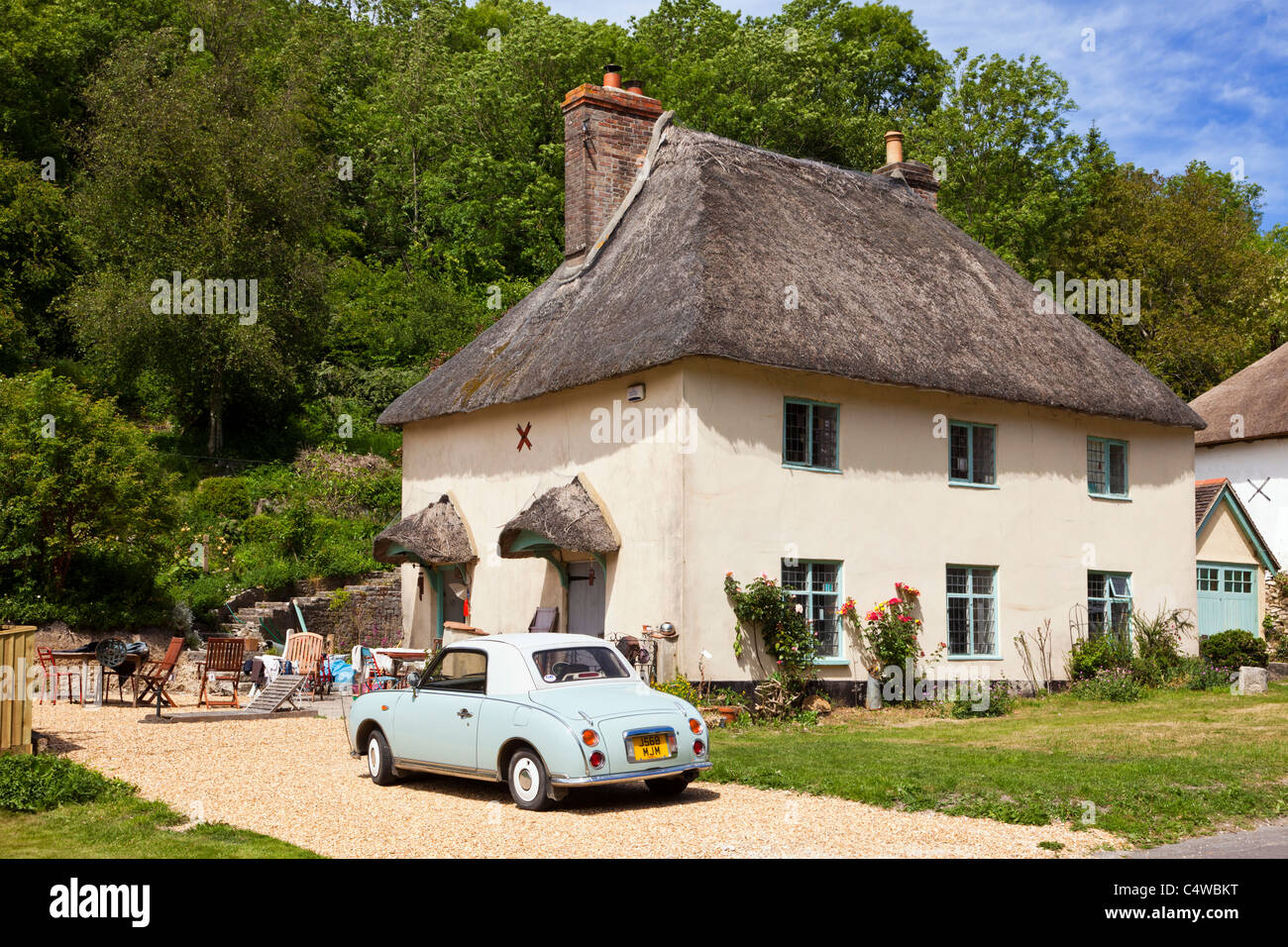 Maison de chaume UK cottage et voiture vintage, dans le village anglais de Milton Abbas, Dorset, Angleterre Banque D'Images