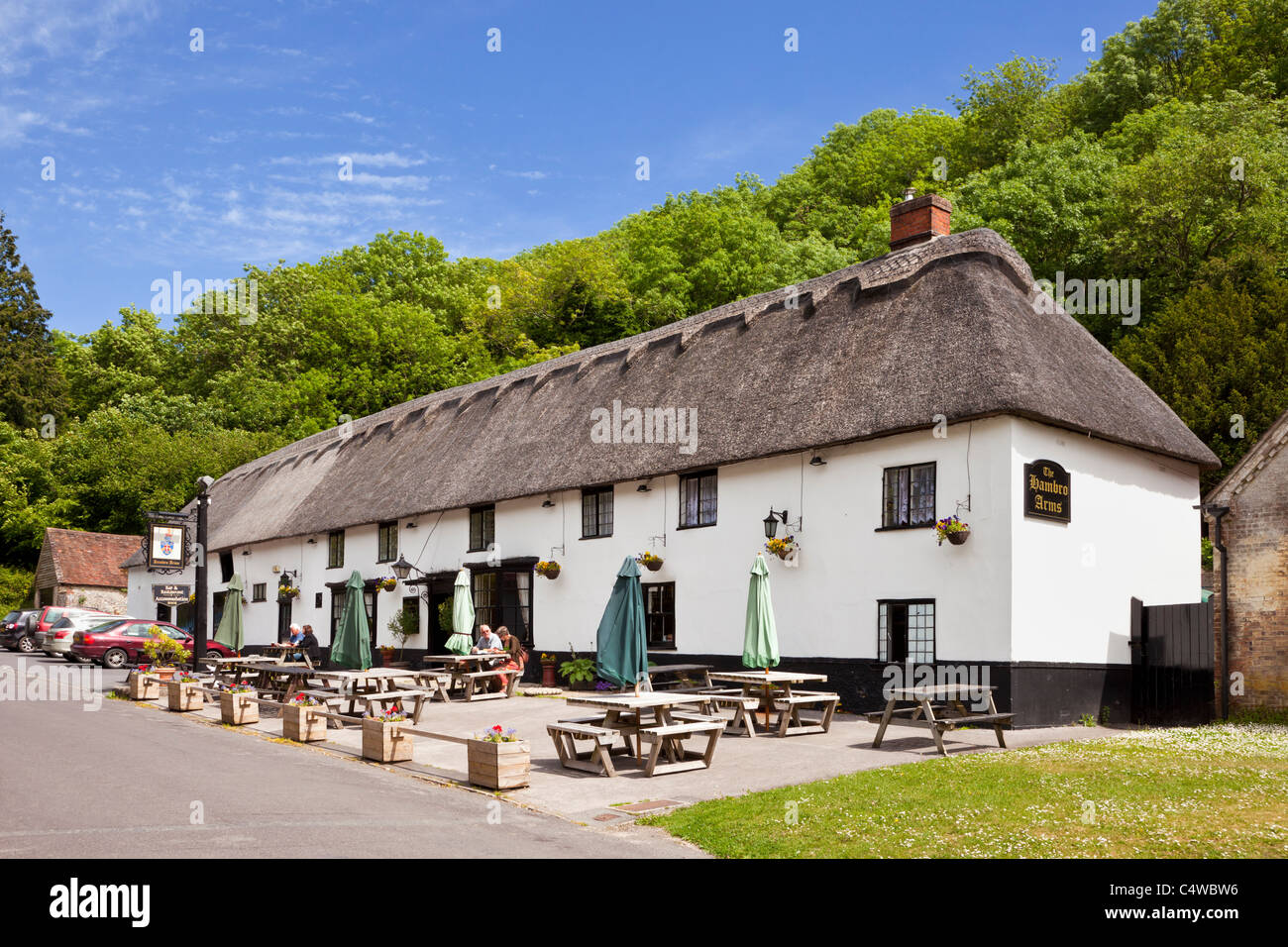 Le pub du village Hambro Arms avec toit de chaume dans le joli village anglais de Milton Abbas, Dorset, England, UK Banque D'Images