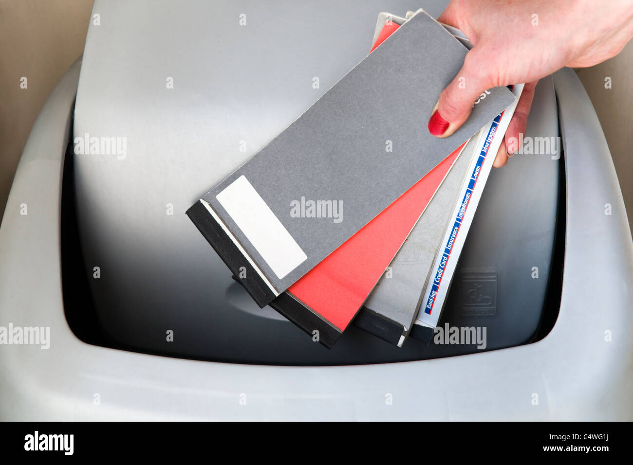 Image montrant la main de femme caucasienne vérifier books être jeté dans le bac indiquant le retrait de chèques au Royaume-Uni Banque D'Images