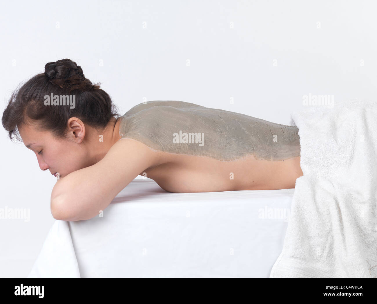 Femme avec enveloppement à l'argile de bentonite masque sur son dos Banque D'Images