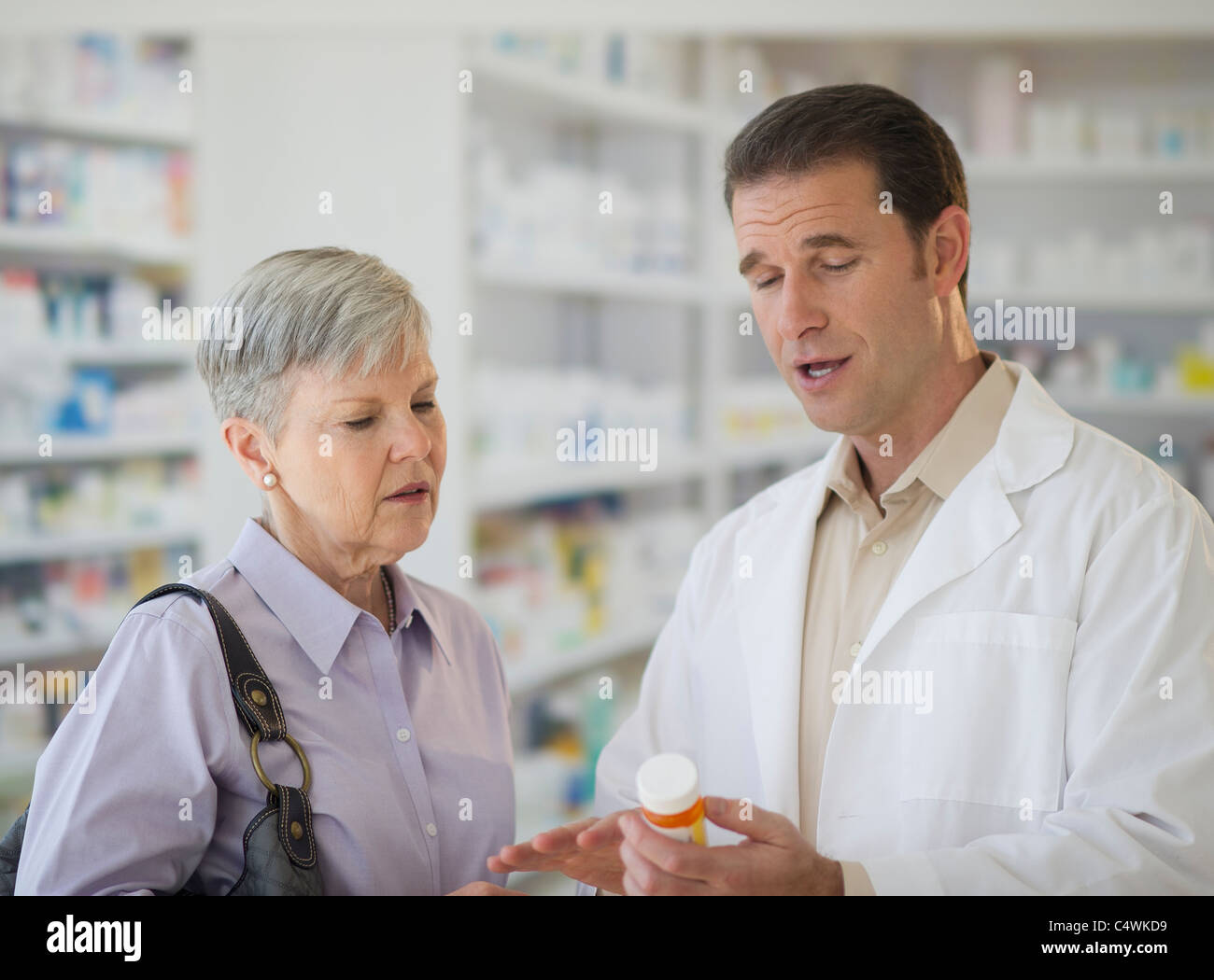 USA, New Jersey, Jersey City, Senior femme parlant à votre pharmacien Banque D'Images
