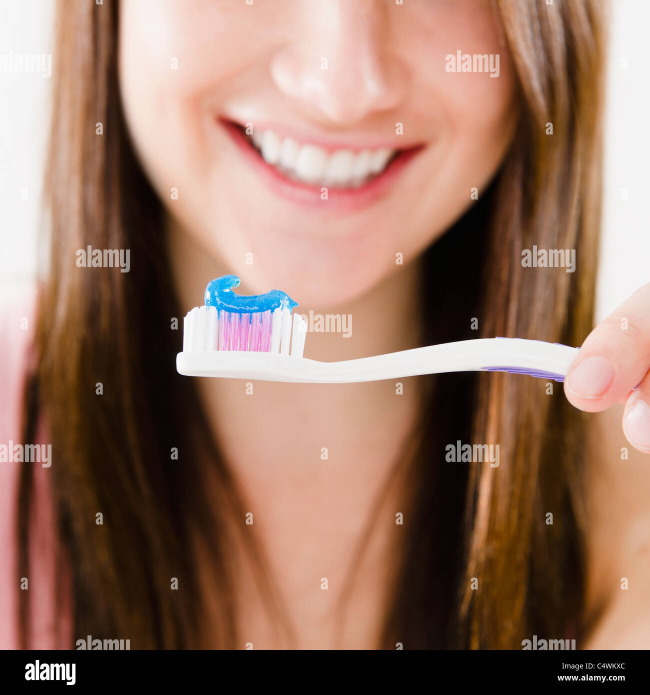 Close-up of smiling young woman holding toothbrush Banque D'Images