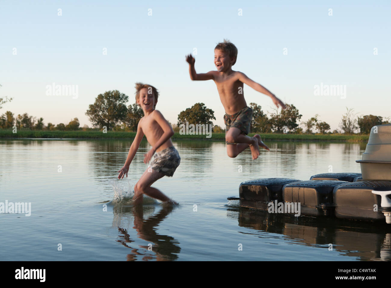 USA,Texas,Texarkana,deux garçons (8-9) sauter dans le lac Banque D'Images