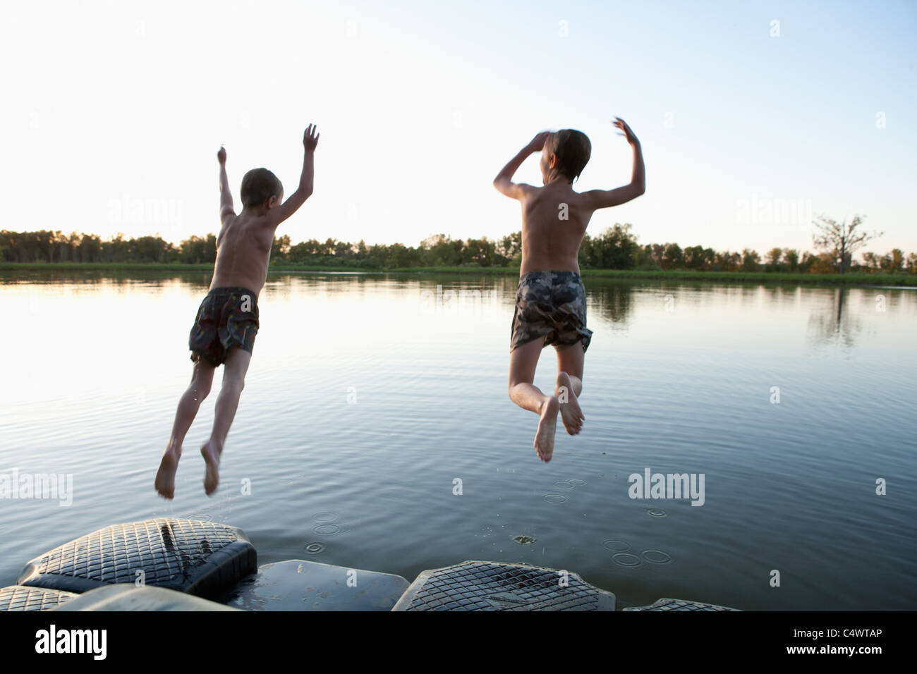 USA,Texas,Texarkana,deux garçons (8-9) sauter dans le lac Banque D'Images