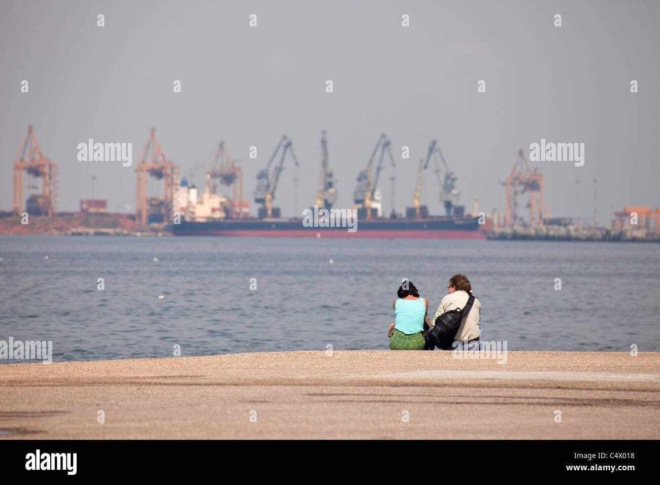 Couple assis à la promenade du front de mer avec vue sur le port de Thessalonique, Macédoine, Grèce Banque D'Images