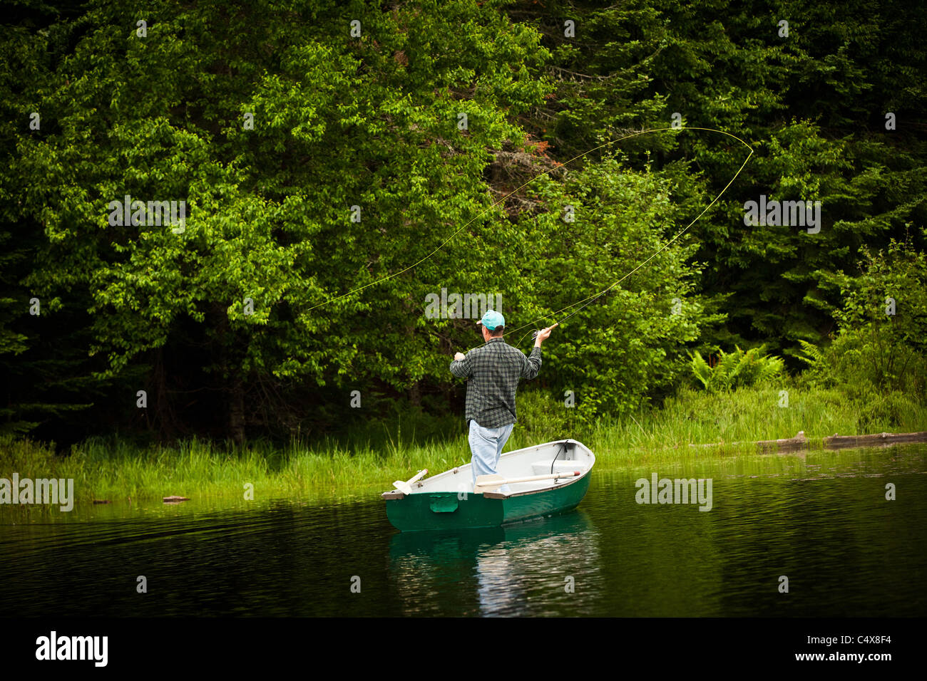 Un homme jette la mouche truite sur un lac à Boulder Junction, Wisconsin. Banque D'Images