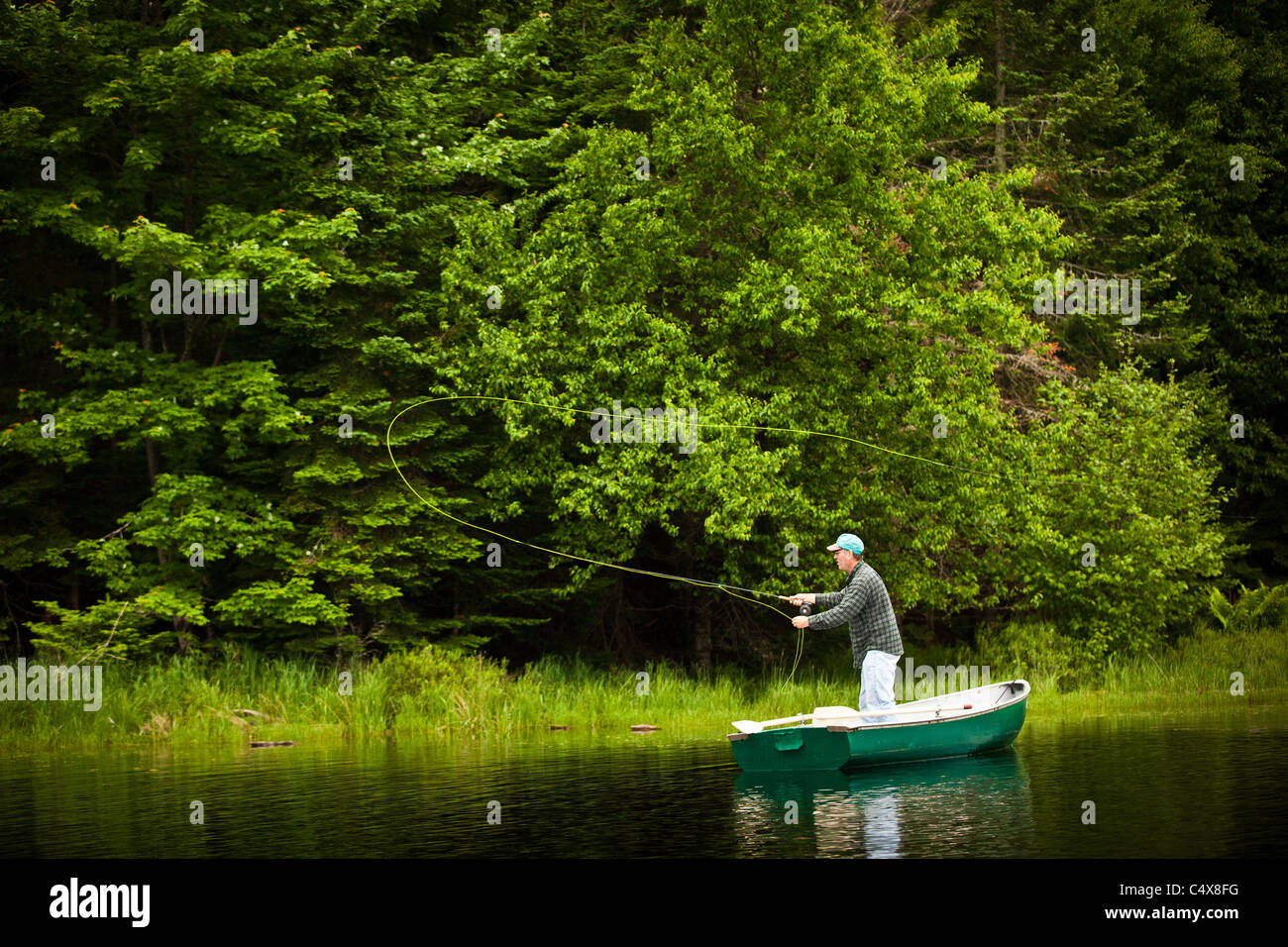 Un homme jette la mouche truite sur un lac à Boulder Junction, Wisconsin. Banque D'Images