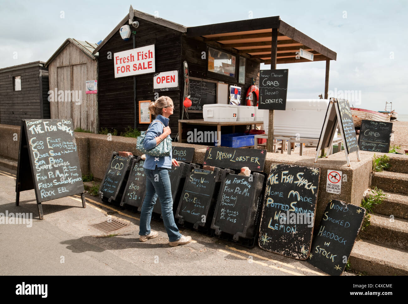 Une femme à la recherche de poisson frais, le poisson Shack, UK Suffolk Aldeburgh Banque D'Images