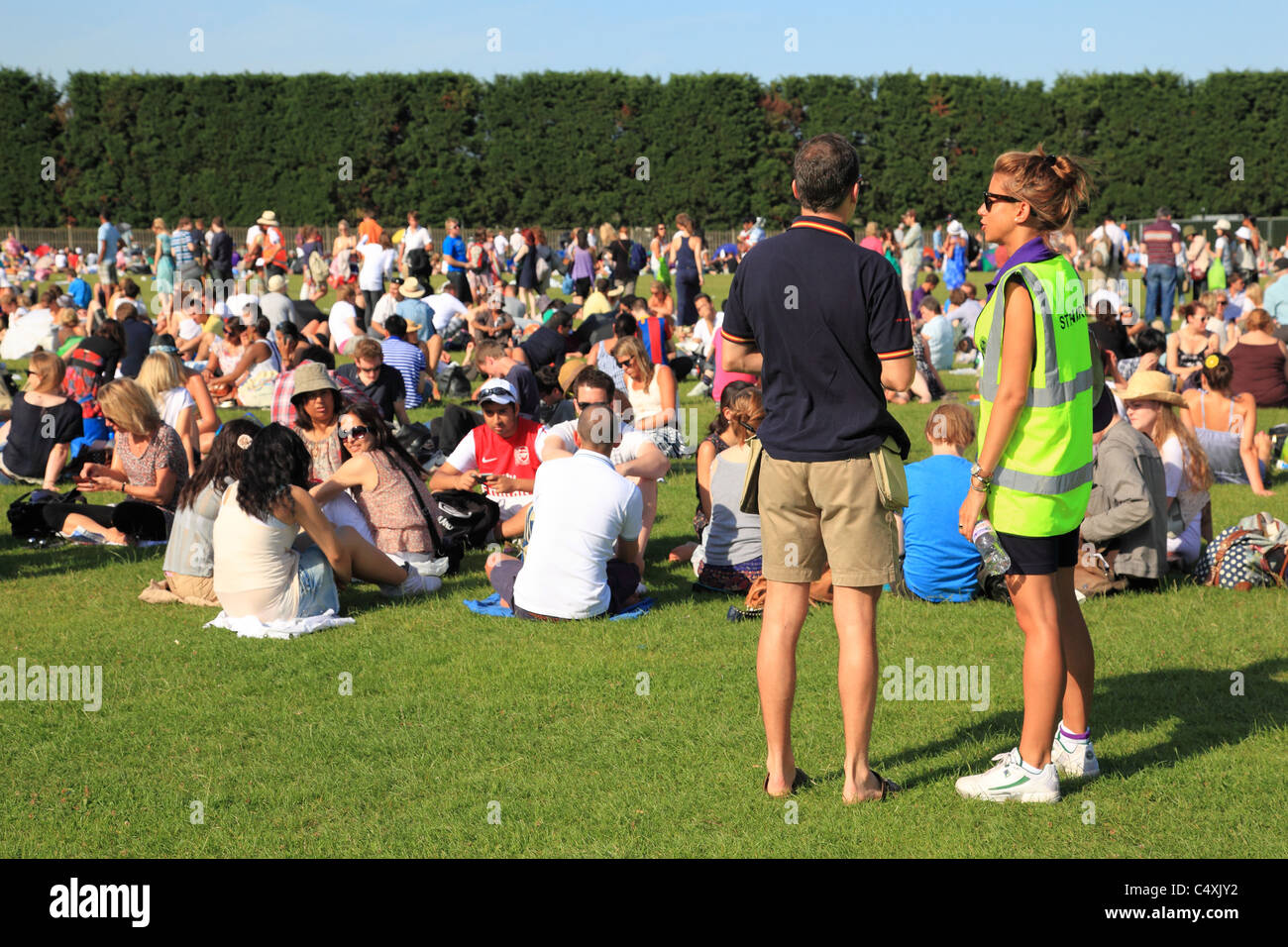 Steward et les gens font la queue pour l'entrée au tournoi de tennis de Wimbledon, Surrey, Angleterre Banque D'Images