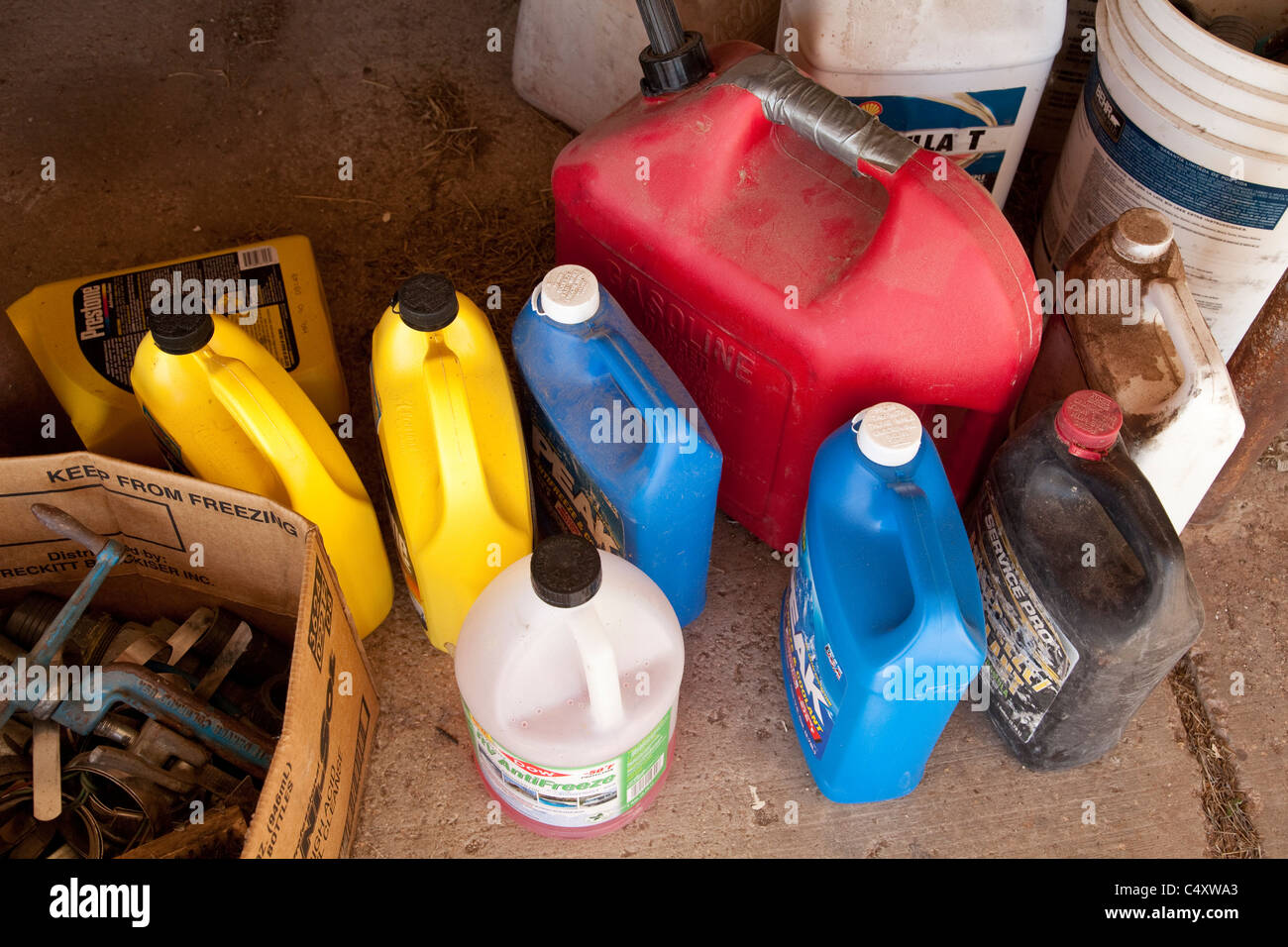 Produits utilisés pour maintenir les outils électriques et les moteurs dans les bouteilles en plastique s'asseoir sur le plancher d'un hangar de stockage à un ranch dans TX Banque D'Images