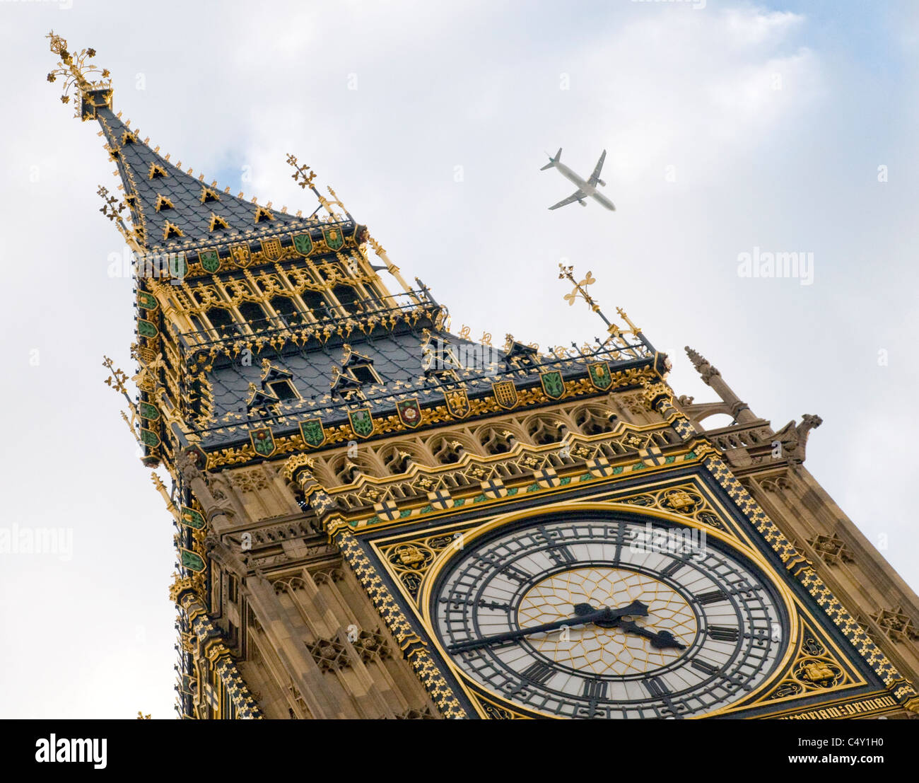 Close up obscure vue sur Big Ben clock tower à Westminster, Londres avec avion volant au-dessus. Banque D'Images