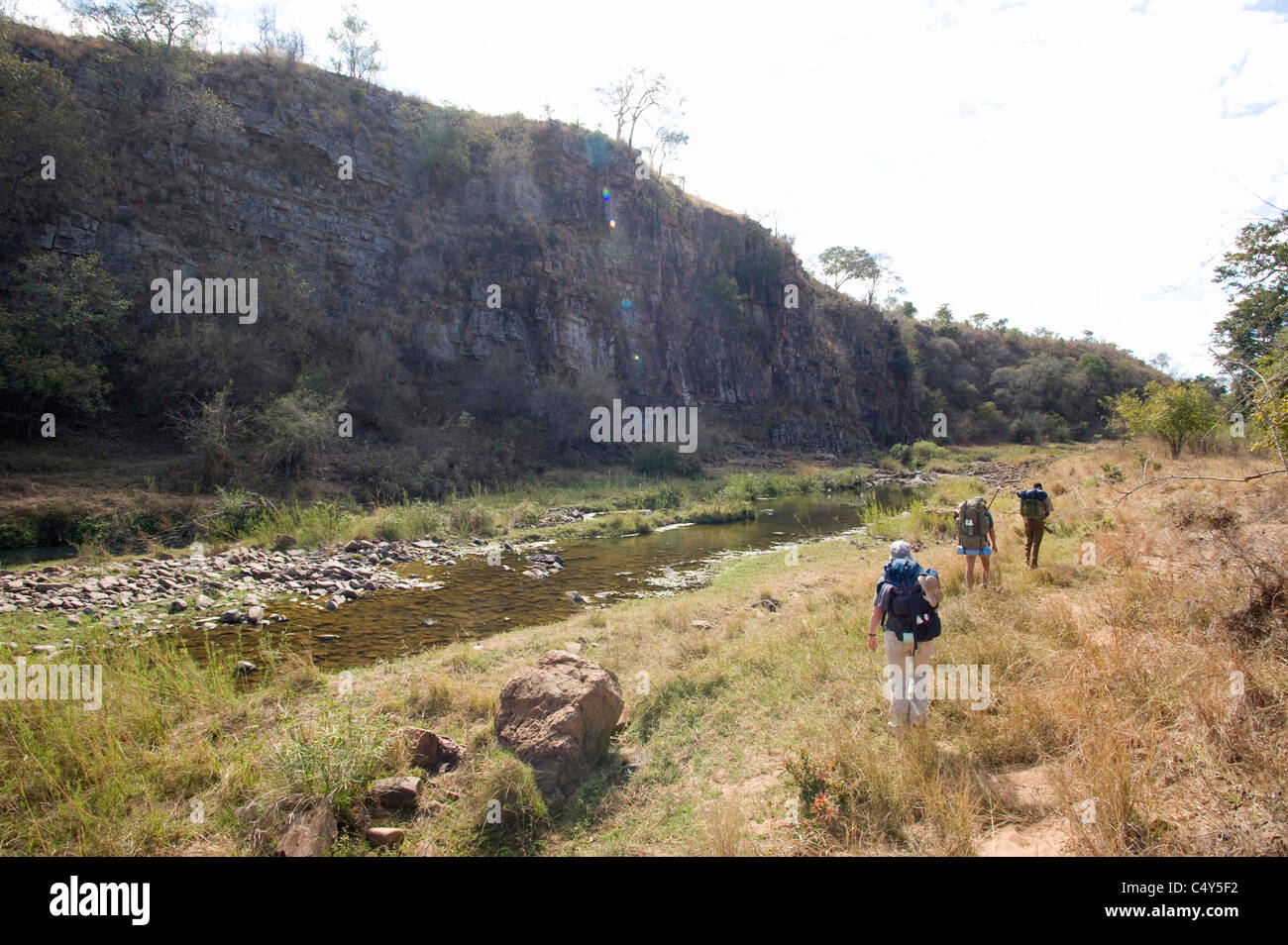 Les randonneurs à pied le long d'une rivière dans le parc national du Zimbabwe Chizarira Banque D'Images